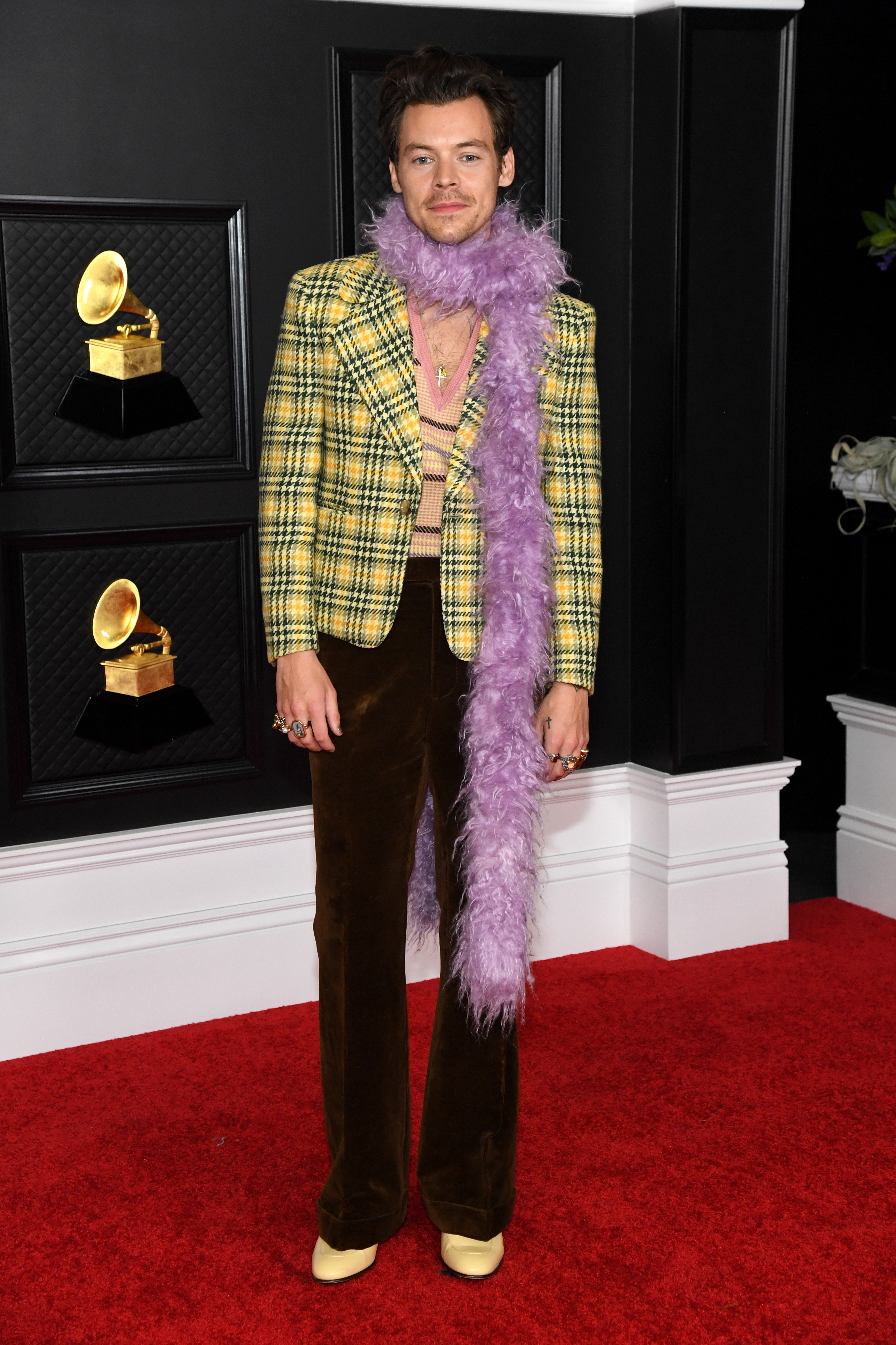 Harry Styles in a pattern blazer, brown trousers and a boa scarf at the Grammy Awards in 2021