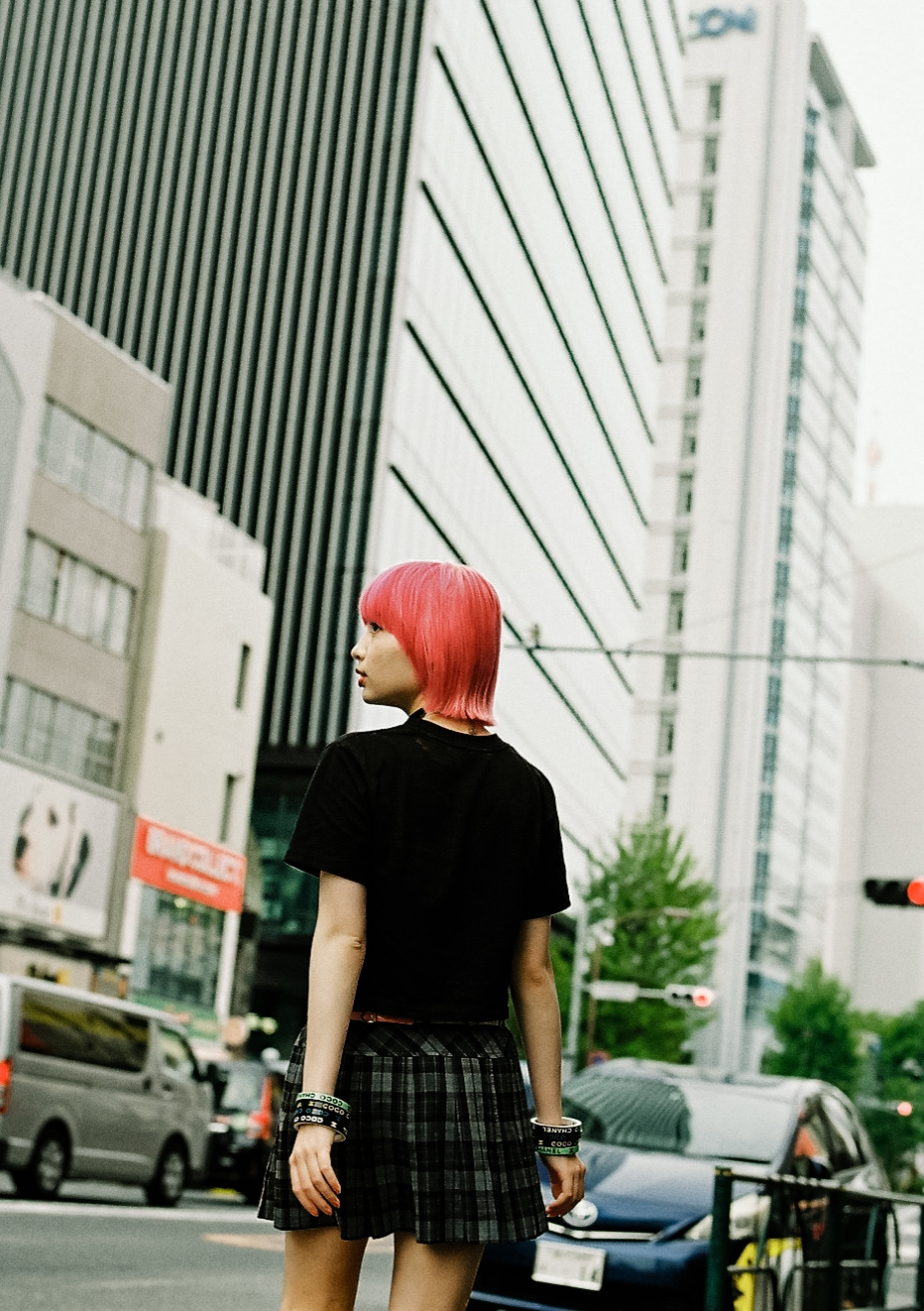 manon, with her back to us, crosses the road in tokyo