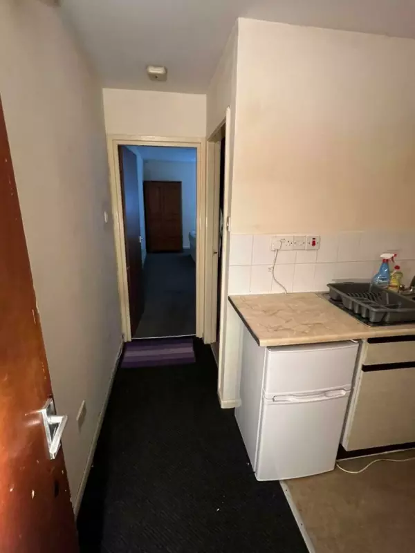 A dark ominous-looking corridor in a tiny studio flat for rent in Birmingham