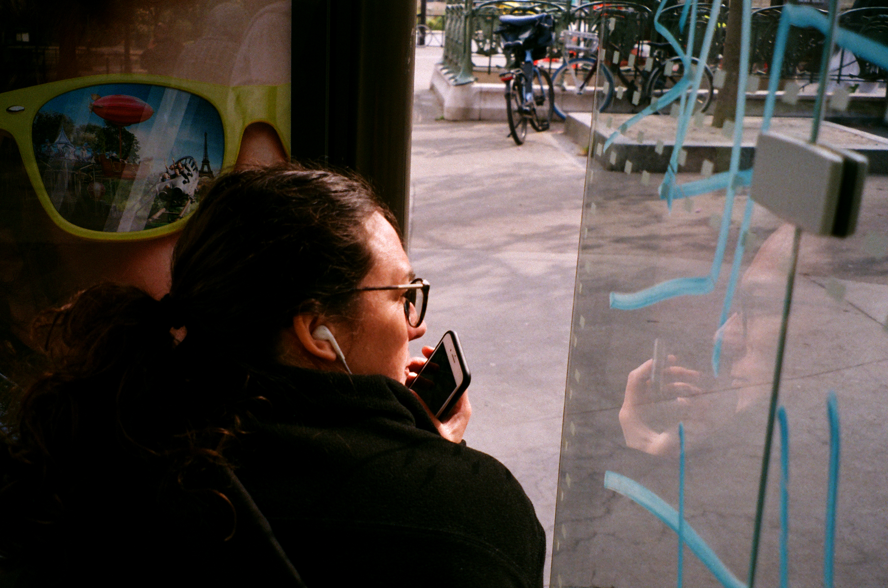 Perempuan muda berbicara sambil mengangkat ponsel