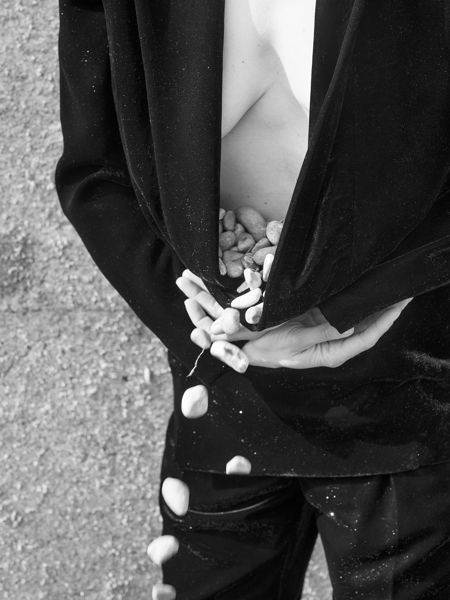 a woman gather pebbles in a jacket in a photo by olivia arthur