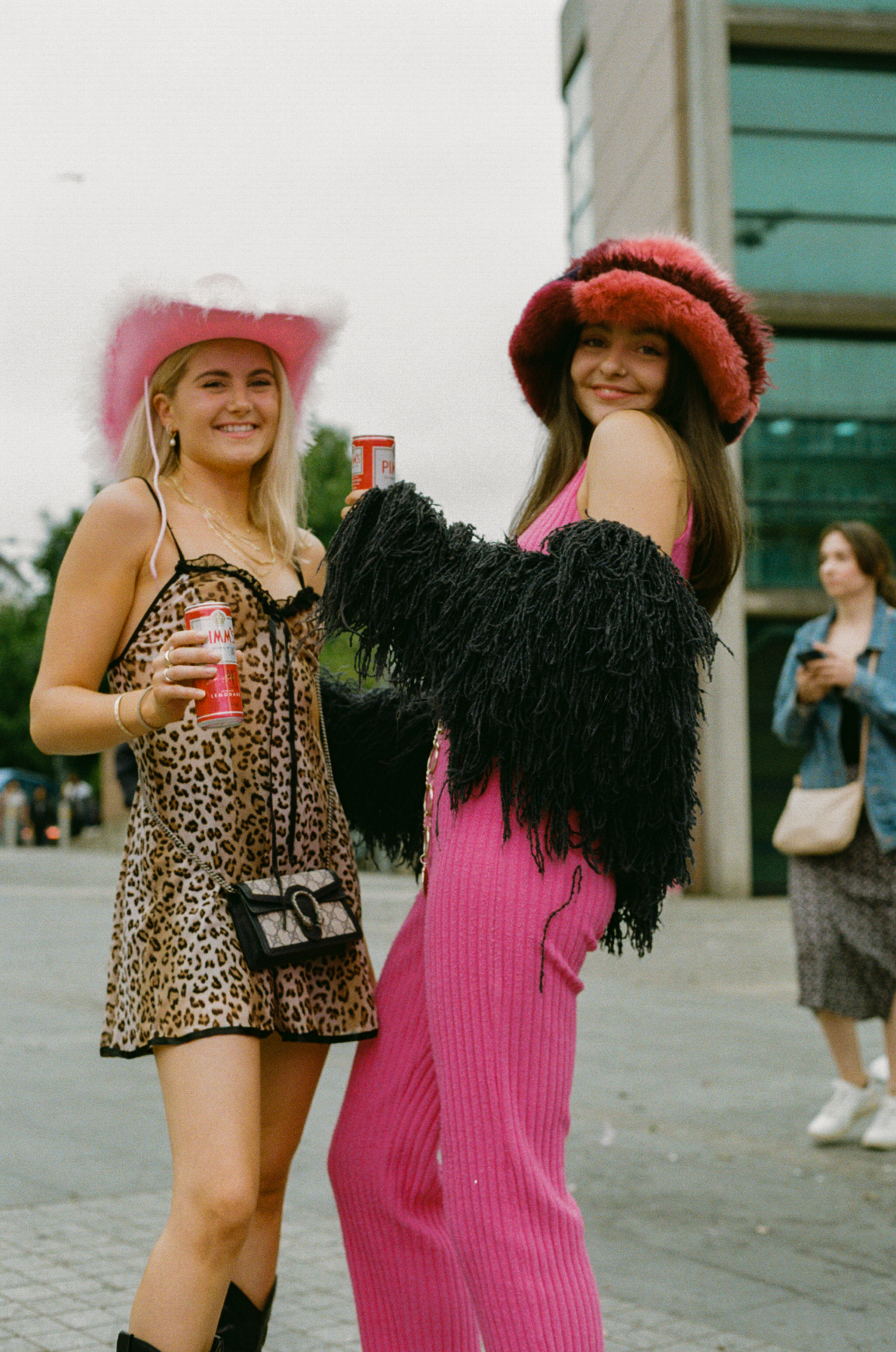 a harry styles fan in a leopard print dress and cowboy hat, another in a pink jumpsuit