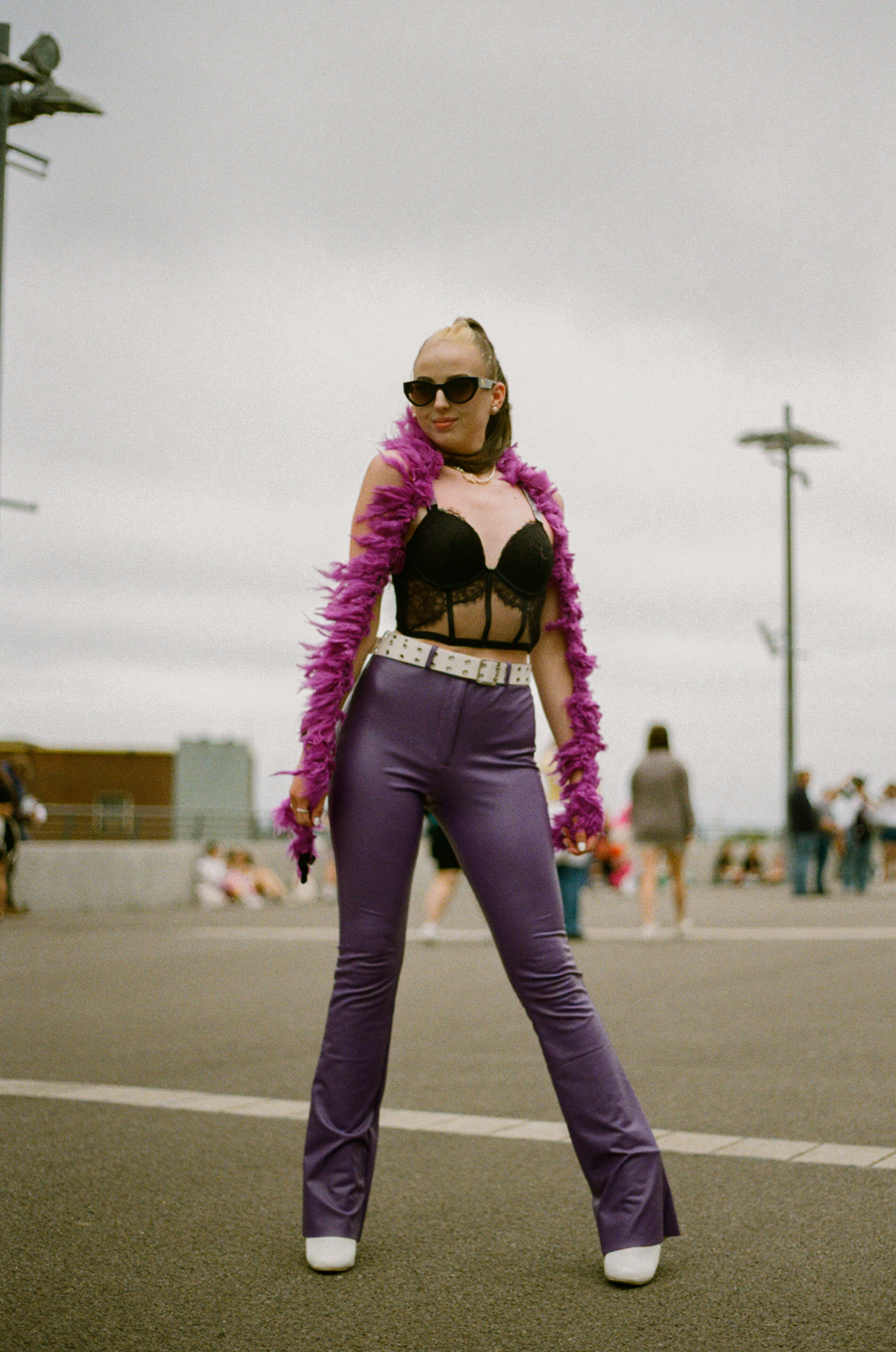 a harry styles fan wearing purple denim flares and a black bralette