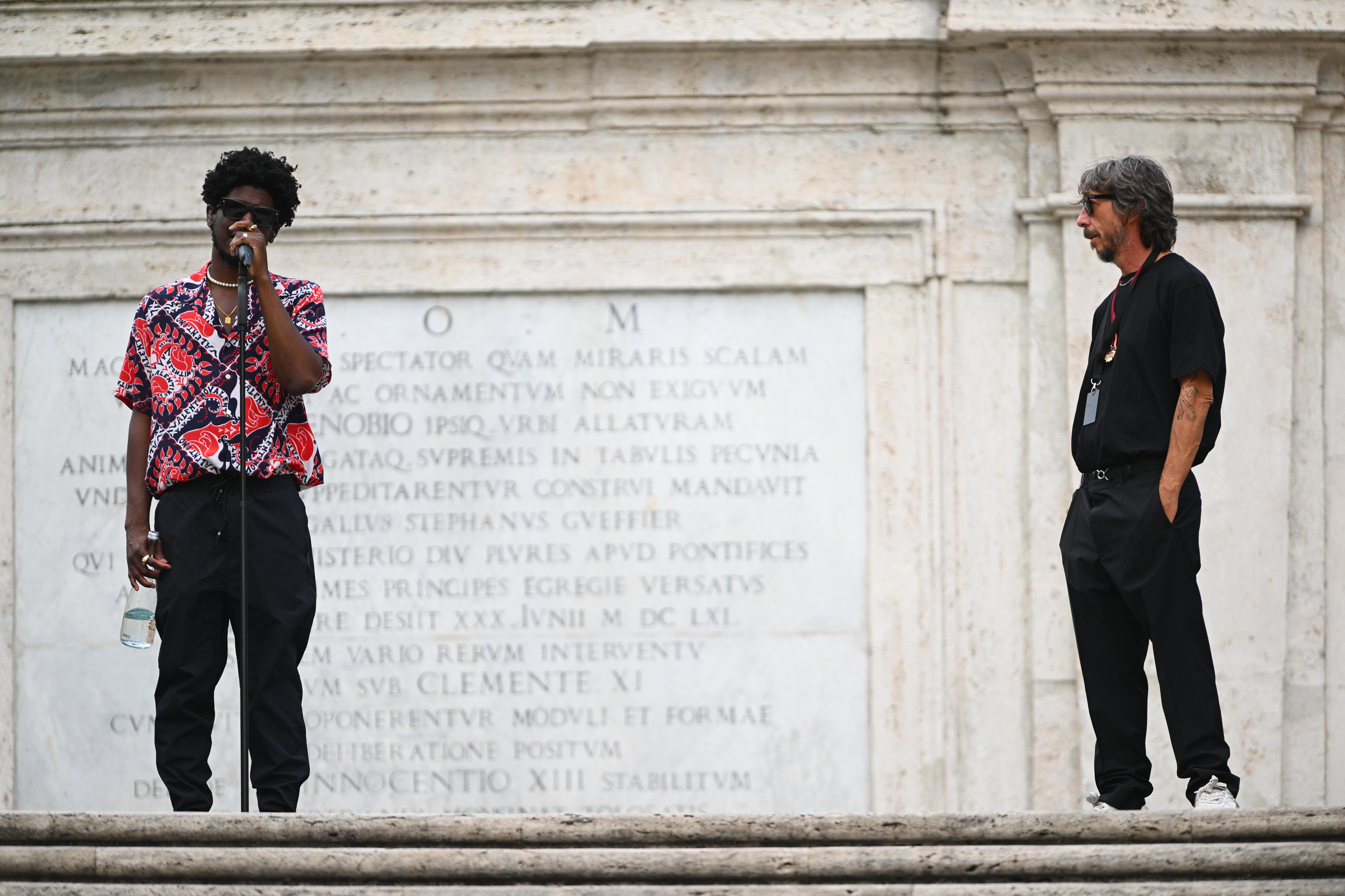 the producer Labrinth and Pierpaolo Piccioli standing on the spanish steps in rome before the Valentino AW22 show