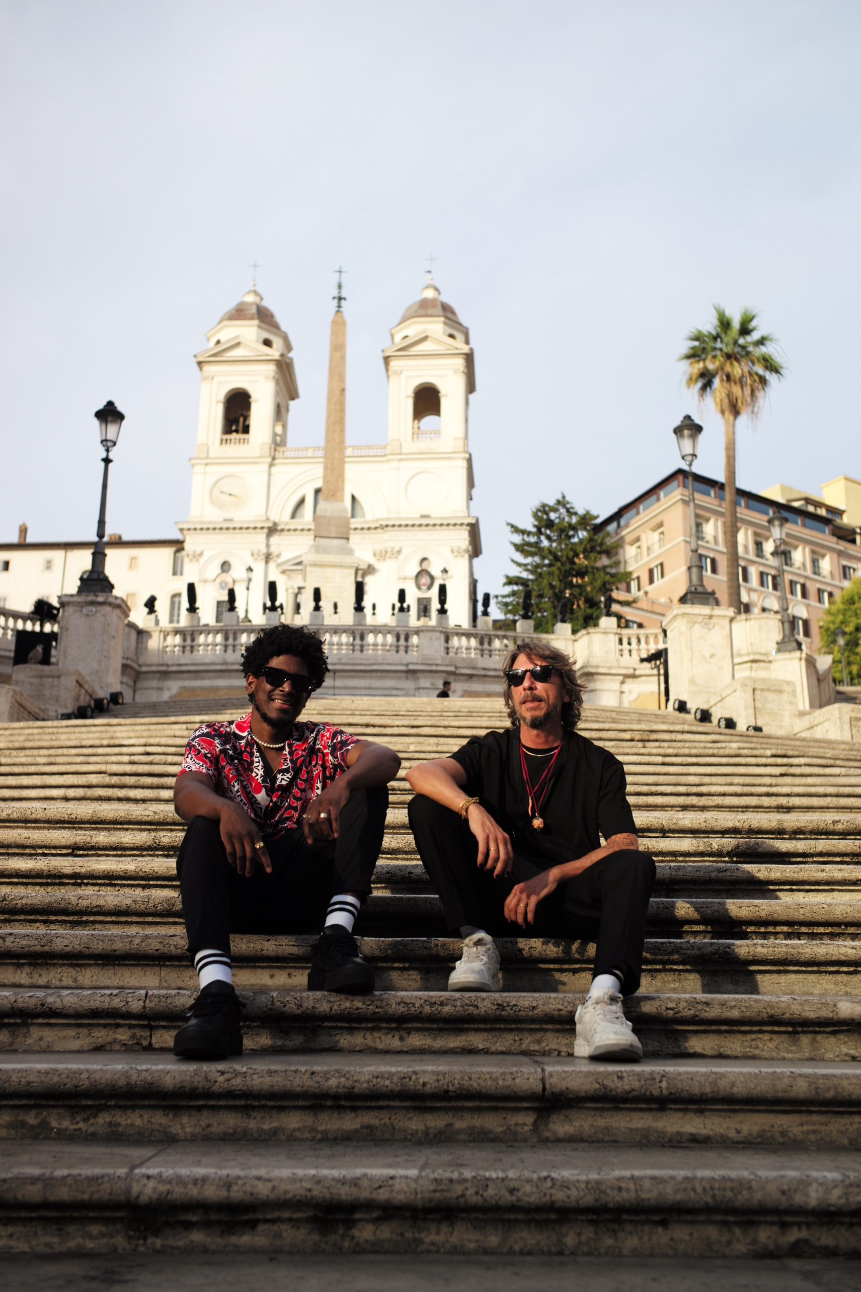 the producer Labrinth and Pierpaolo Piccioli sitting on the spanish steps in rome before the Valentino AW22 show