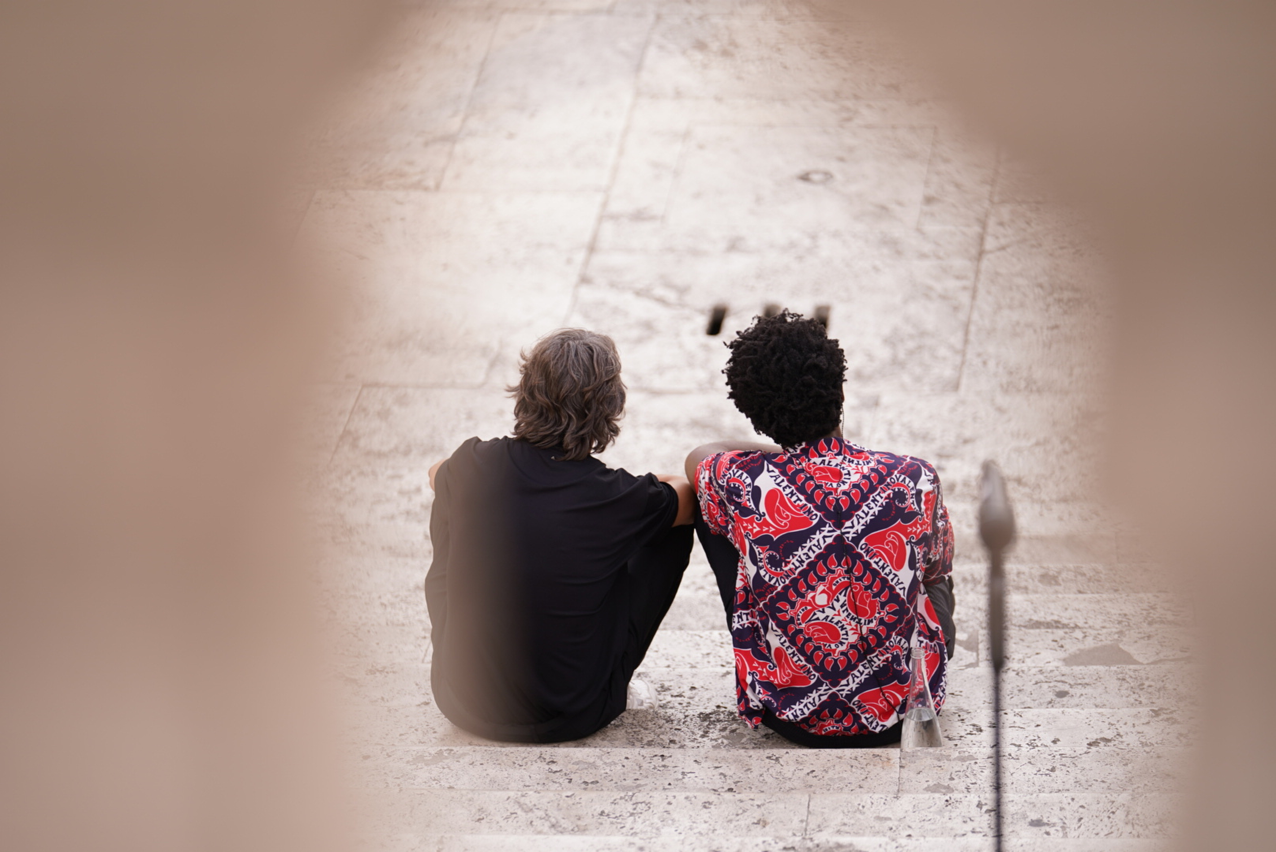 the producer Labrinth and Pierpaolo Piccioli sitting on the spanish steps in Rome – shot from behind