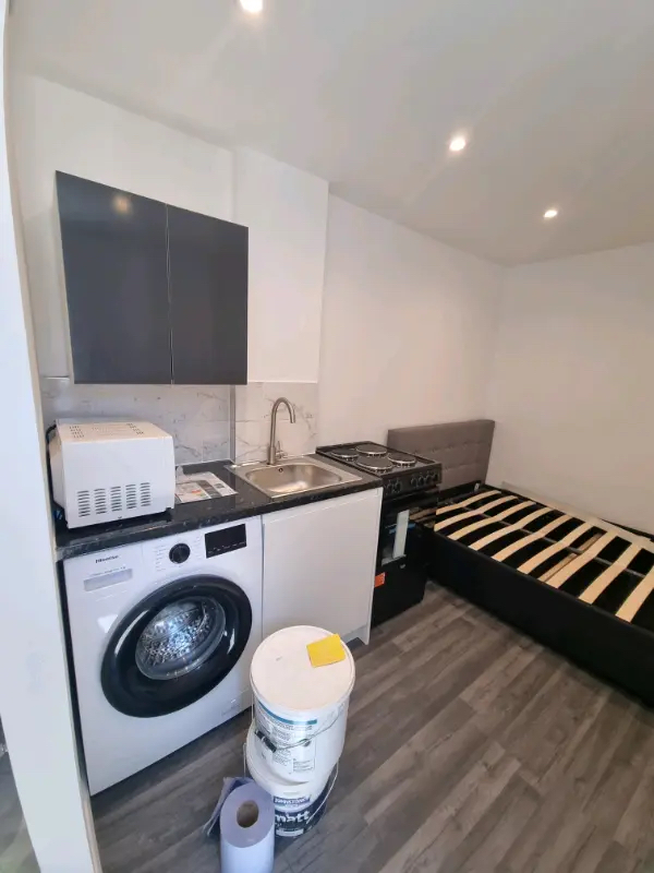 A studio flat in Slough showing the kitchen next to a bed