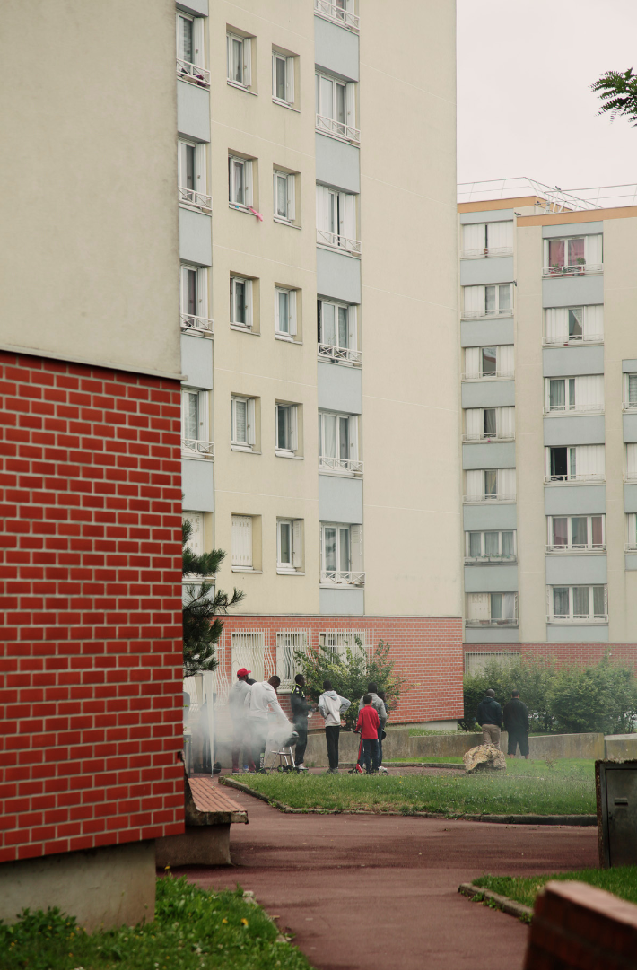 people having a barbecue outside a paris tower block 