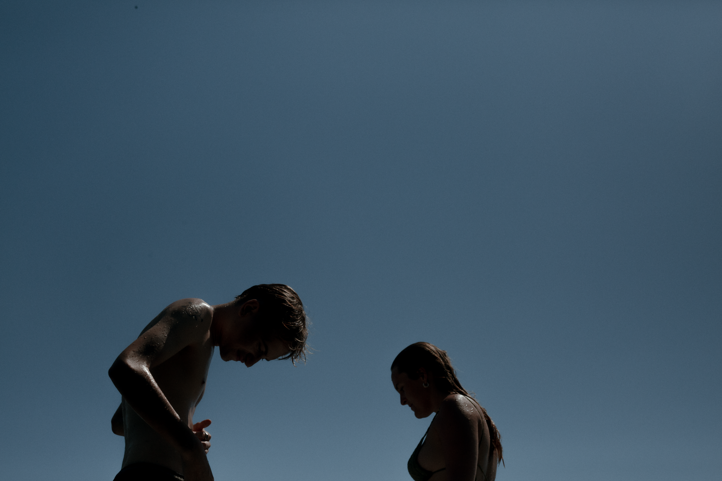 Two people in swimming suits against the blue sky