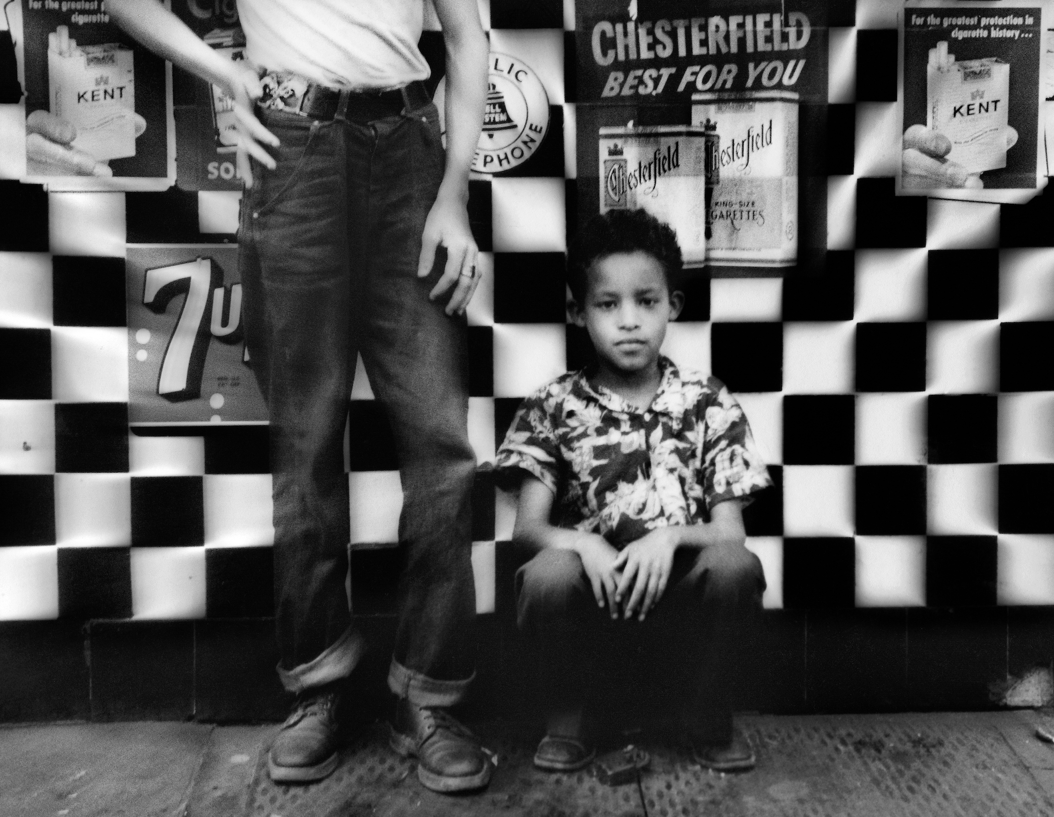 Black-and-white photo of two boys posing in front of a striped restaurant wall