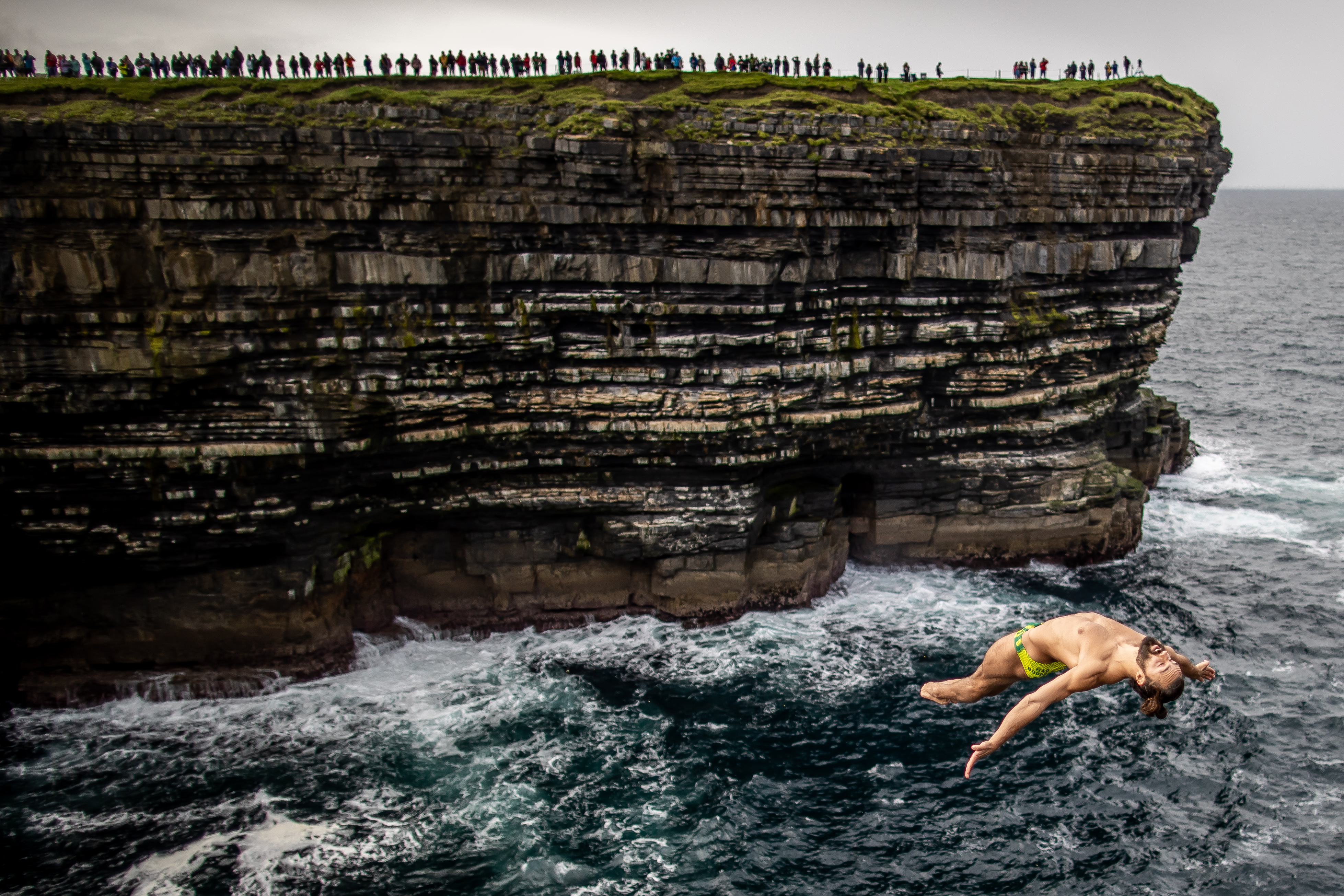 Catalin Preda terjun dari ketinggian 27,5 meter sebelum menyelami laut dengan gerakan akrobatik pada September 2021. Dia mengikuti kompetisi Red Bull Cliff Diving World Series yang diadakan di Irlandia. Foto: Morgan Treacy