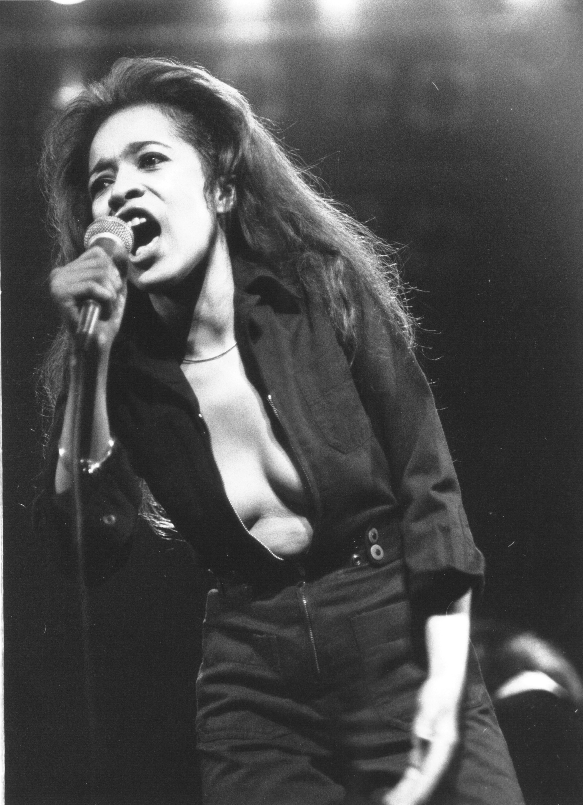 ronnie spector singing into the microphone on stage in a low cut shirt 1977