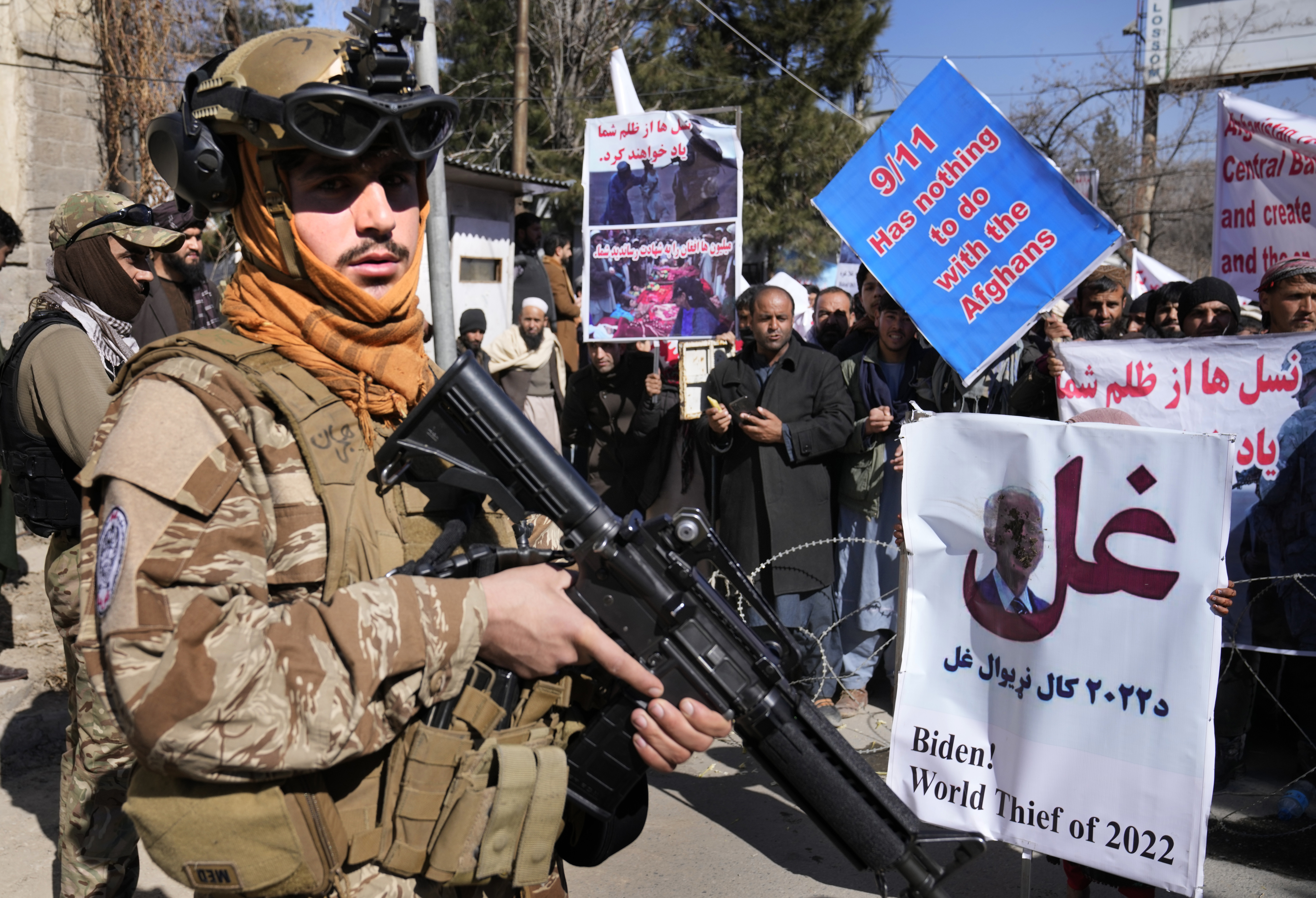 Tentara Taliban berdiri di depan demonstran