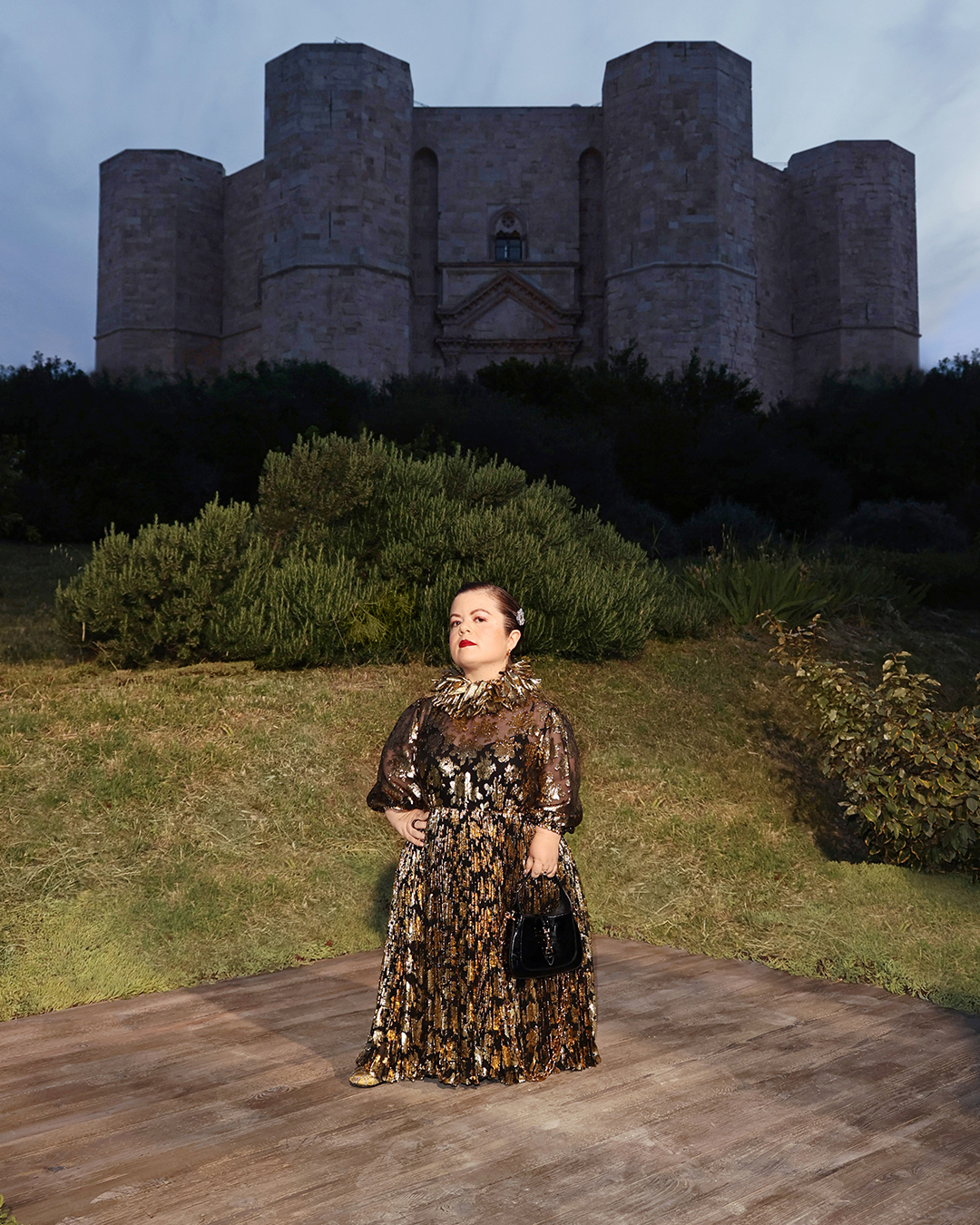 A picture of Sinead Burke in a gold halter gown stood on the bow