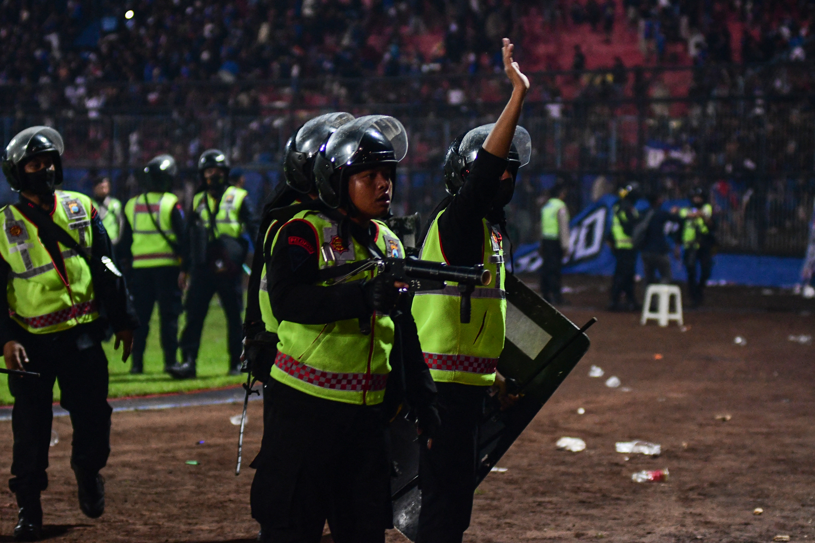 Polisi mengacungkan senjata gas air mata di Stadion Kanjuruhan pada 1 Oktober. Foto: AFP