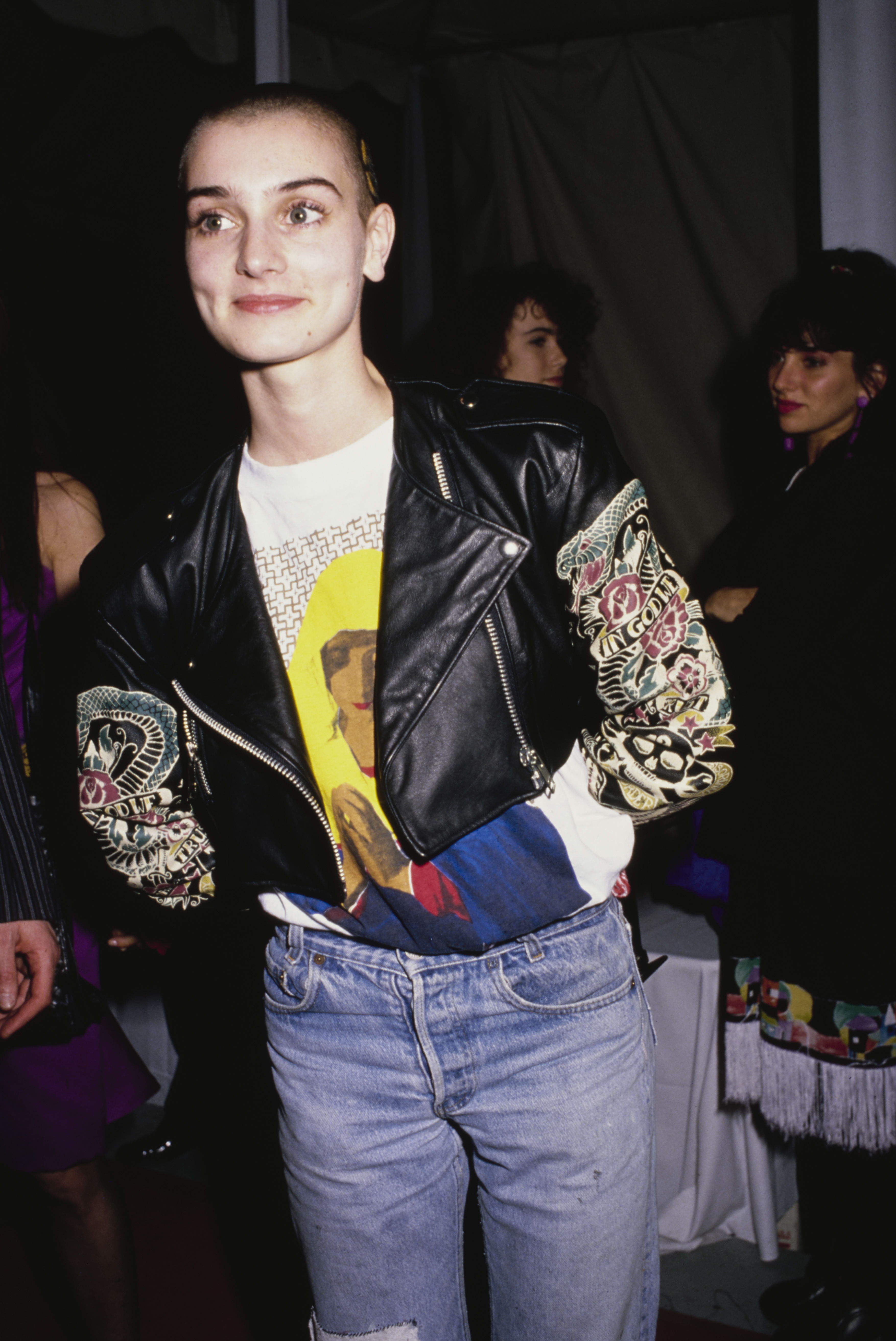 Irish singer-songwriter Sinead O'Connor, wearing a black leather jacket over a t-shirt with an image of a praying Virgin Mary, attends the 31st Annual Grammy Awards, held at the Shrine Auditorium in Los Angeles, California, 22nd February 1989. 
