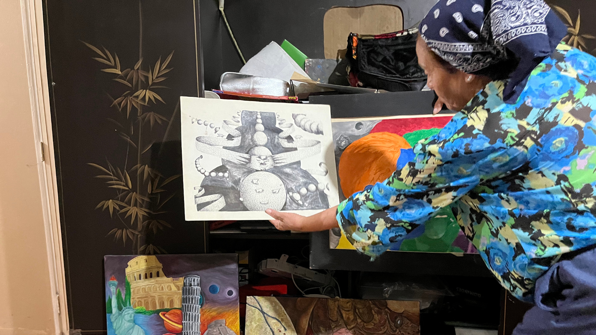 Génesis shows art that her children and grandchildren drew, which she keeps in a closet in her mobile home unit. (Alex Lubben / VICE News)