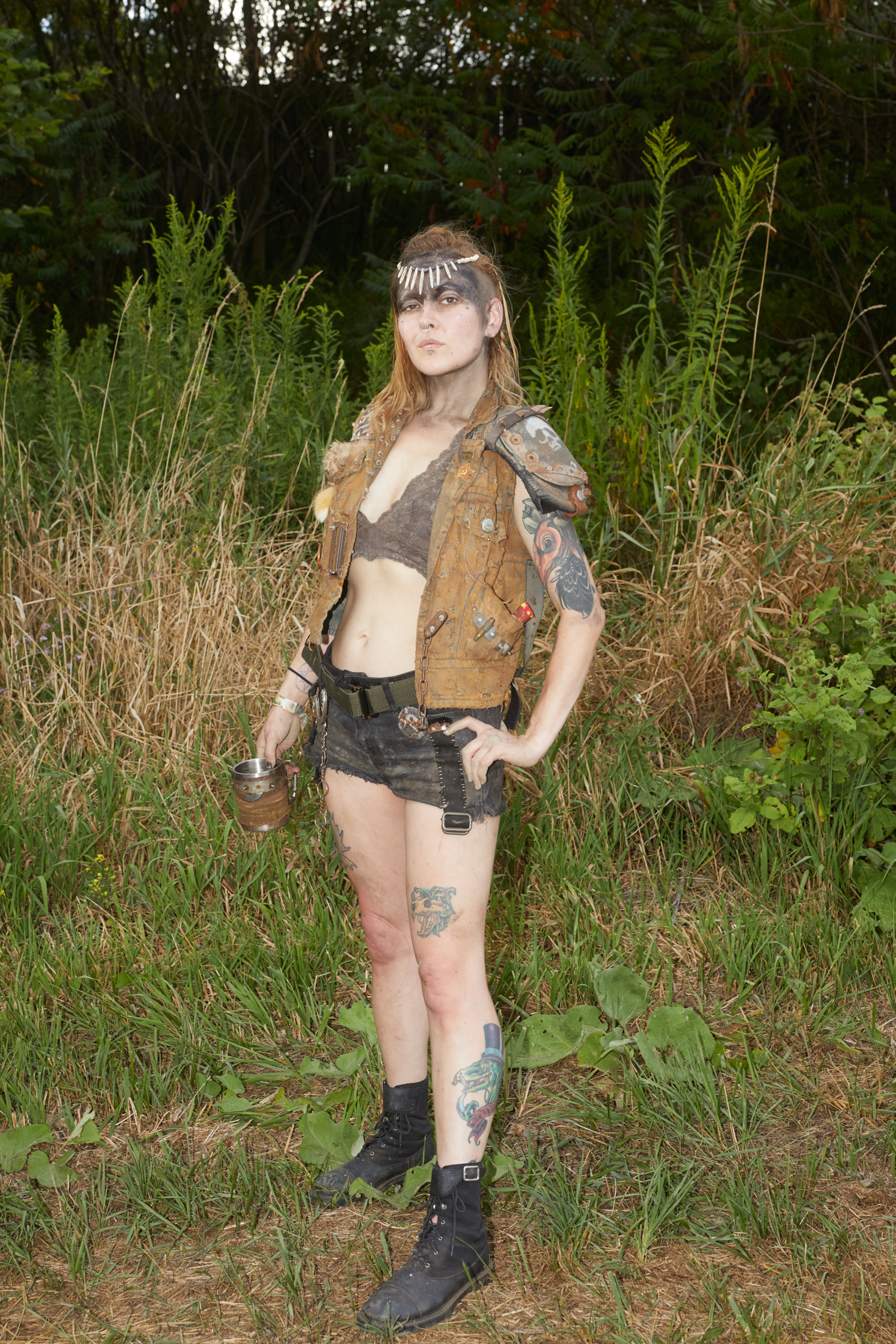 A woman in the forest dressed in a post-apocalyptic costume