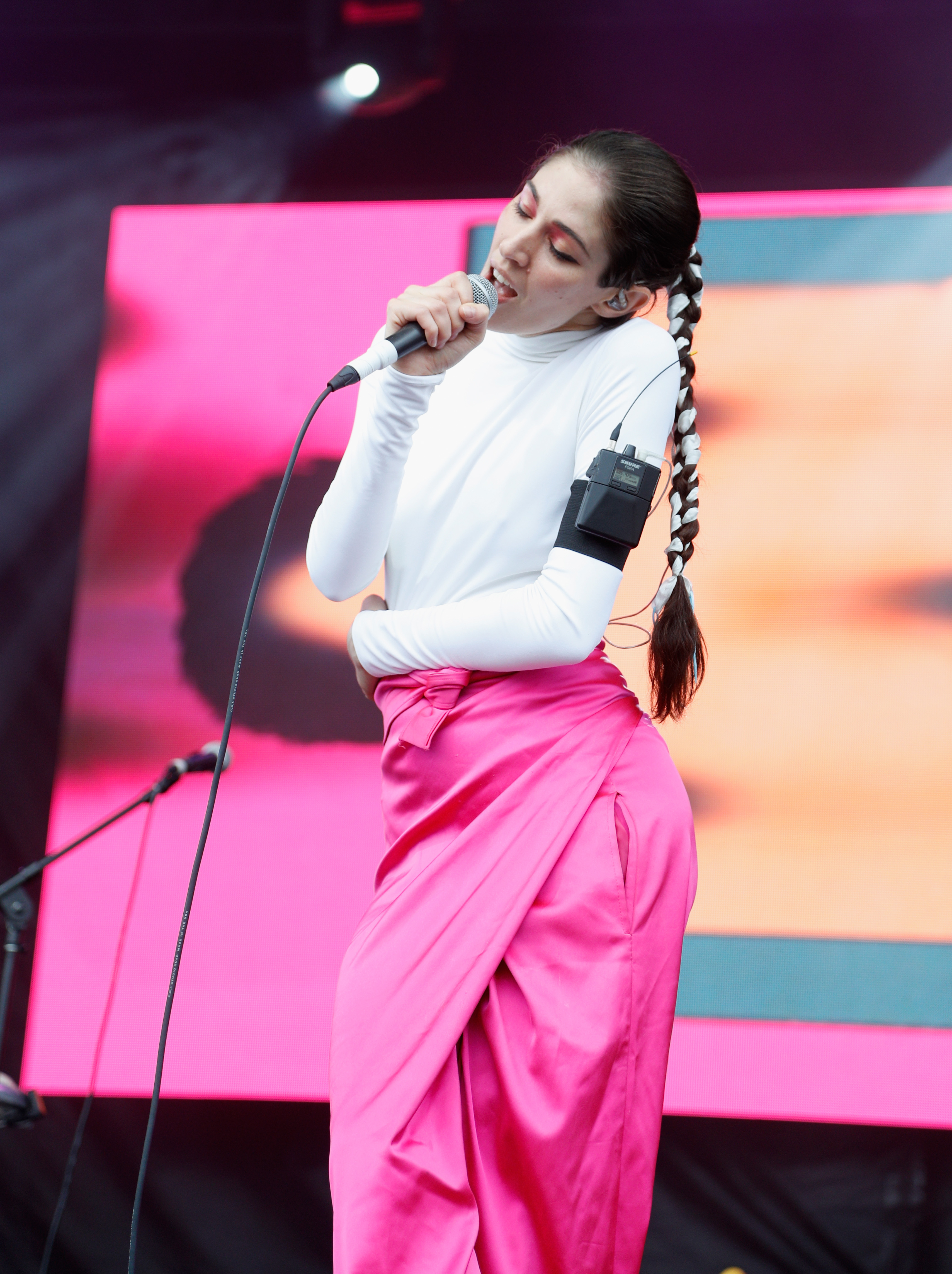 caroline polachek in hot pink trousers performing on stage 