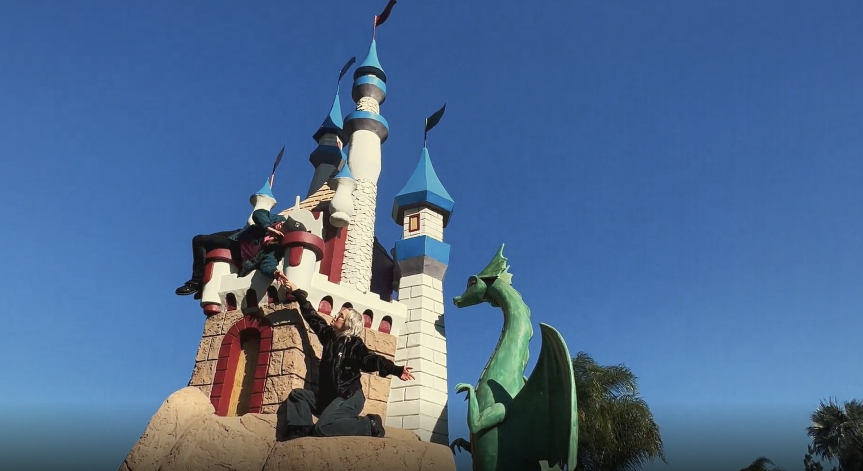 phoebe bridgers on a disney-style castle with a dragon at a mini golf centre