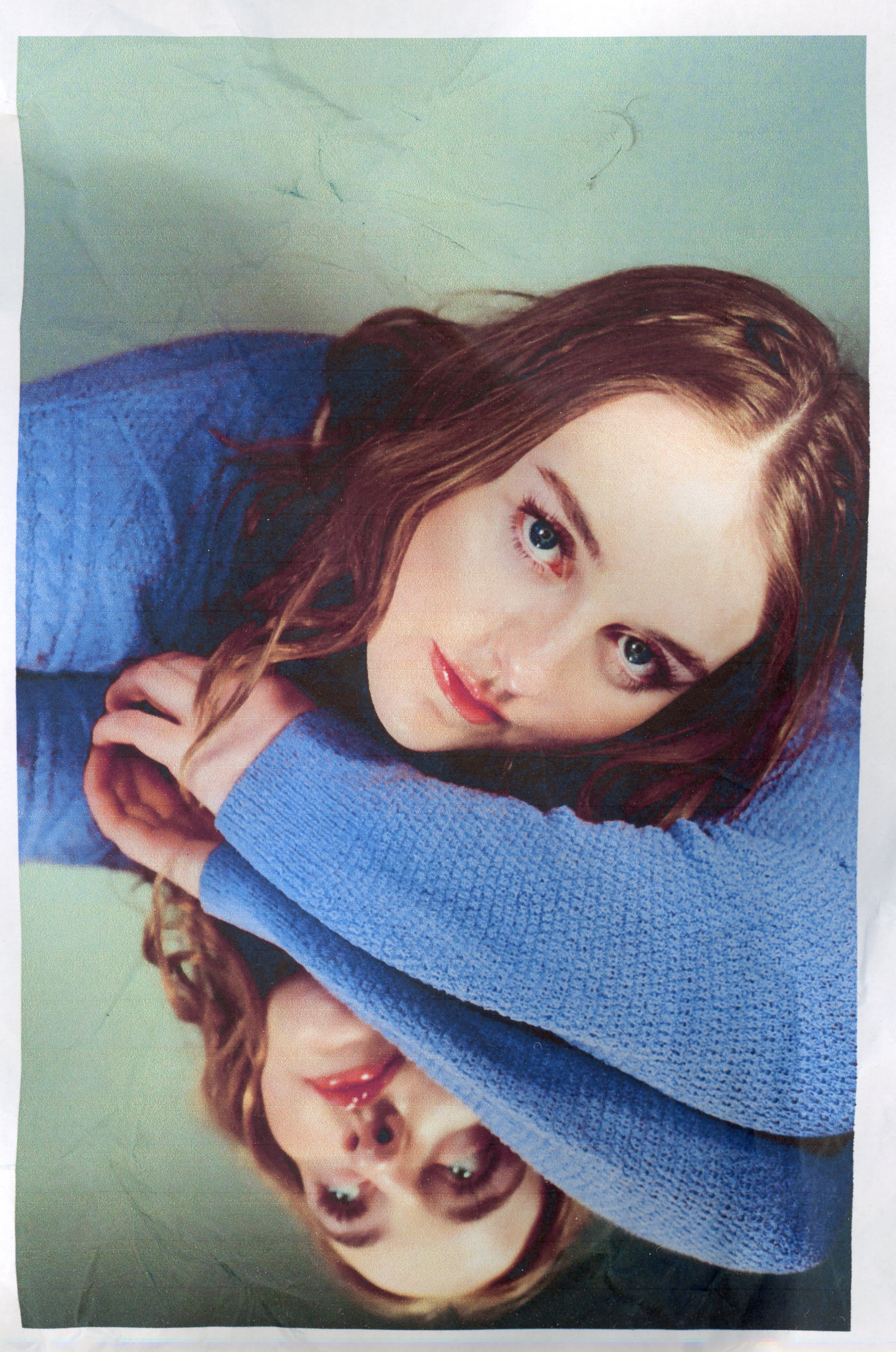 a picture of nell mescal in a blue jumper against a green background