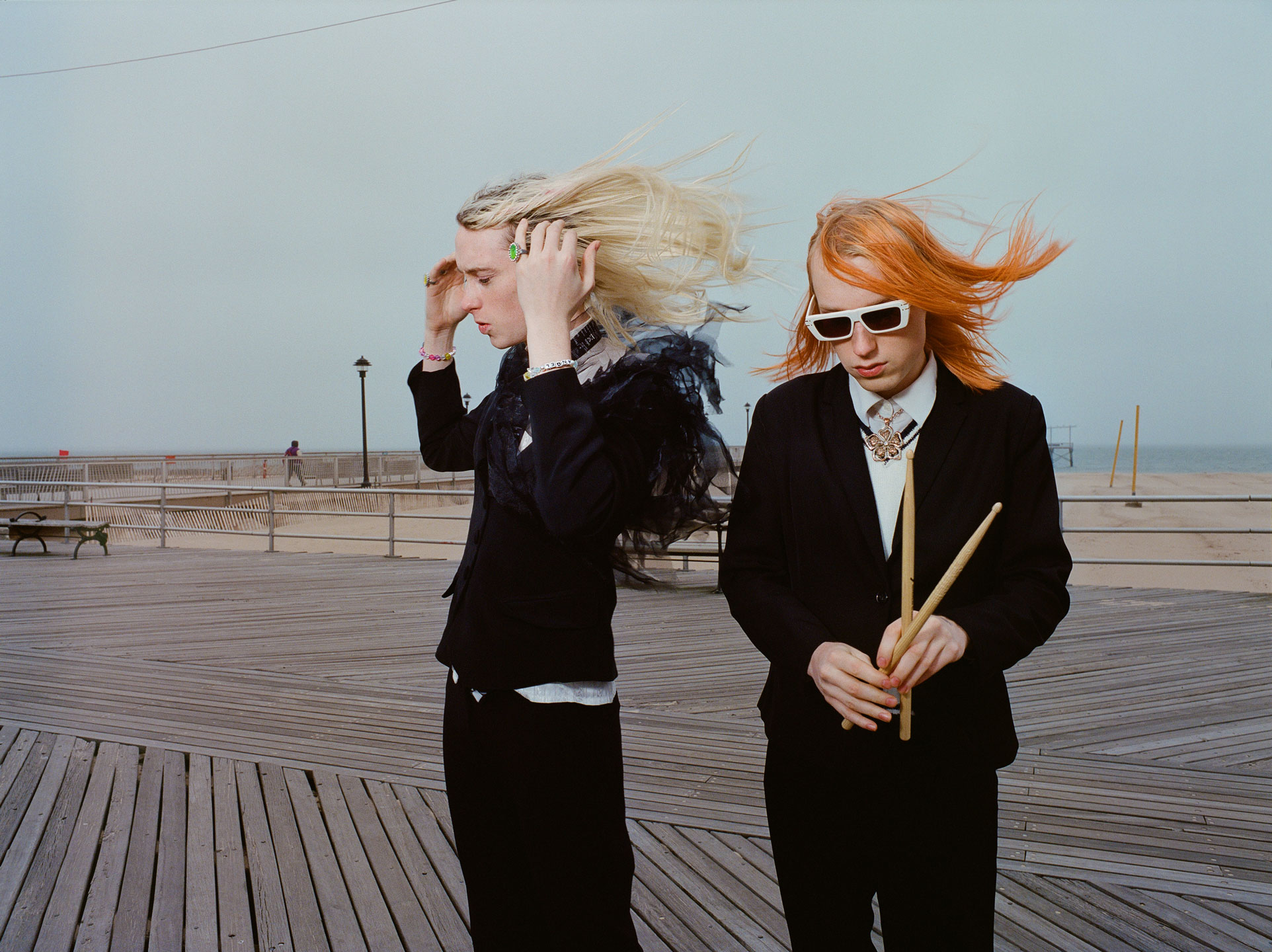 frost children stand on coney island boardwalk, the wind blowing their hair