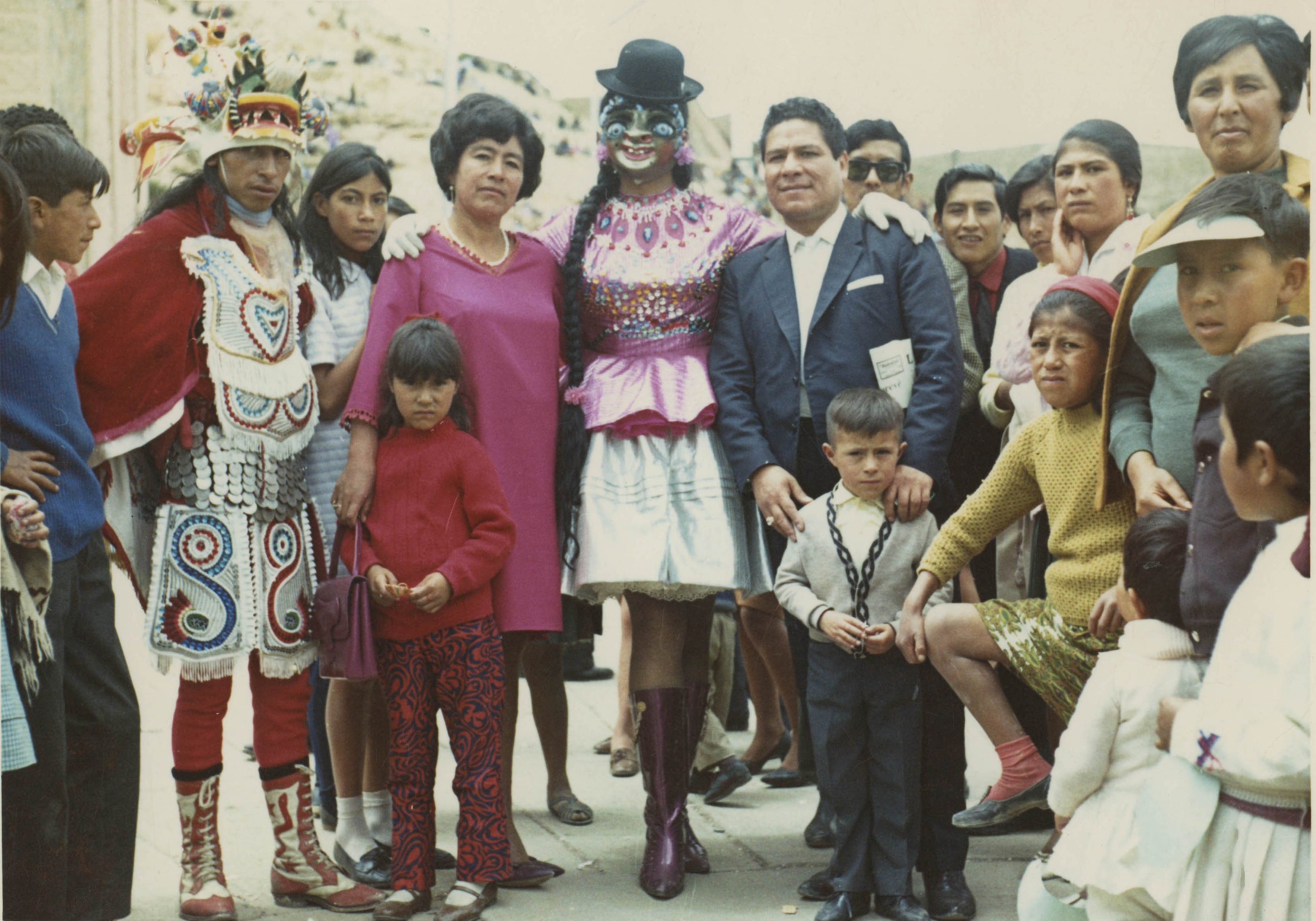 A travesti performer dressed as La China Morena in Bolivia, stood with a family 