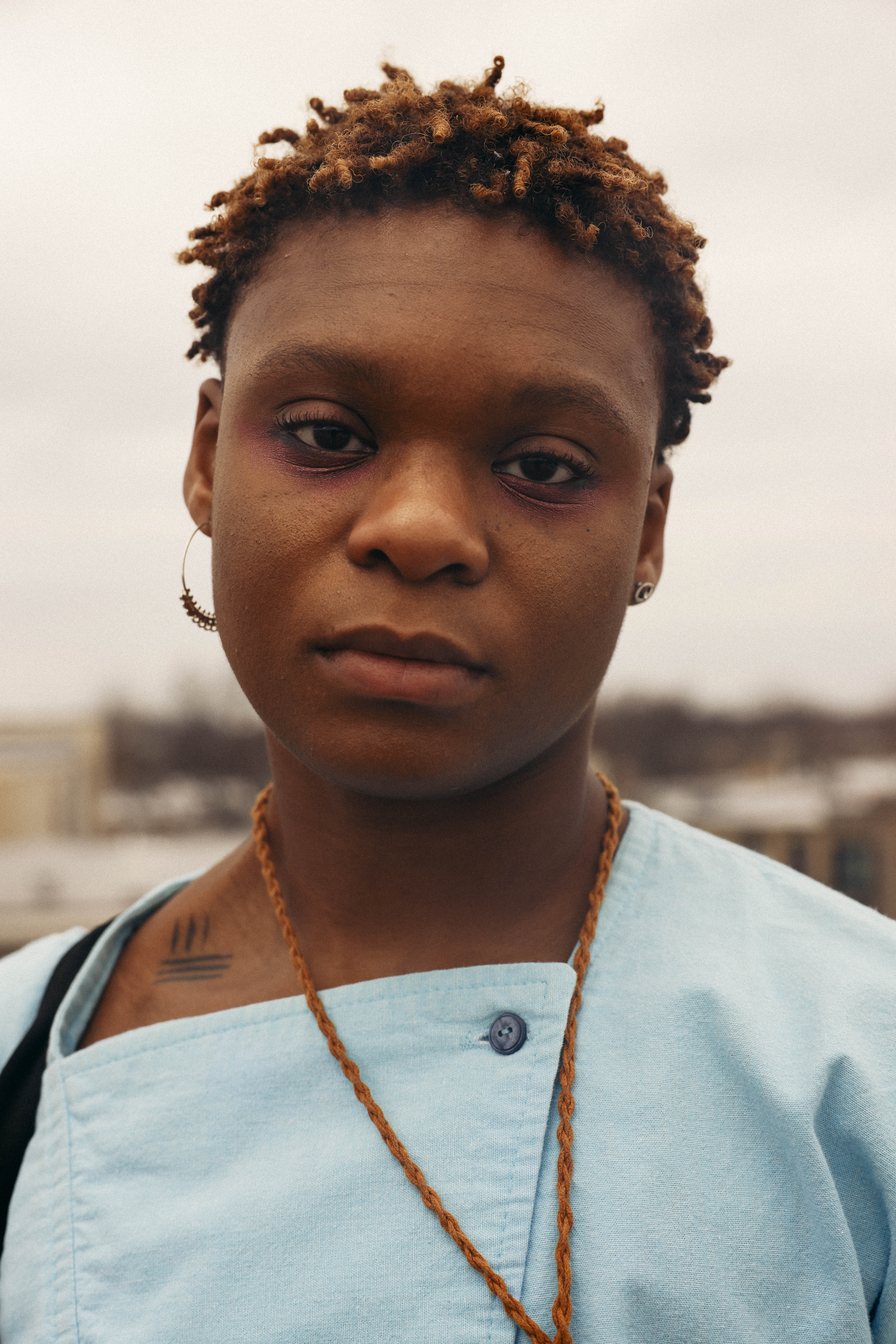 close up portrait of dreamer isioma in a blue shirt and earrings