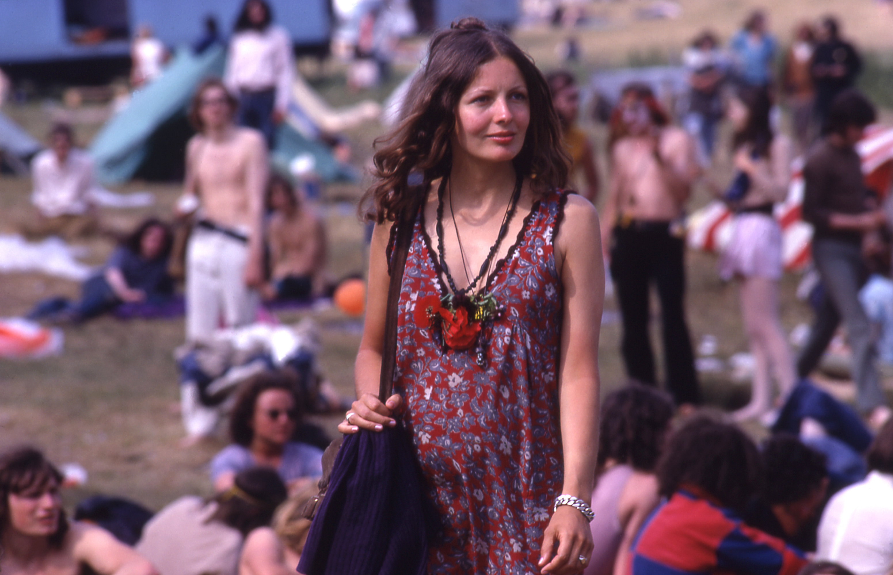 Dee Harkin wearing a red floral dress in the middle of a field at glastonbury 1971