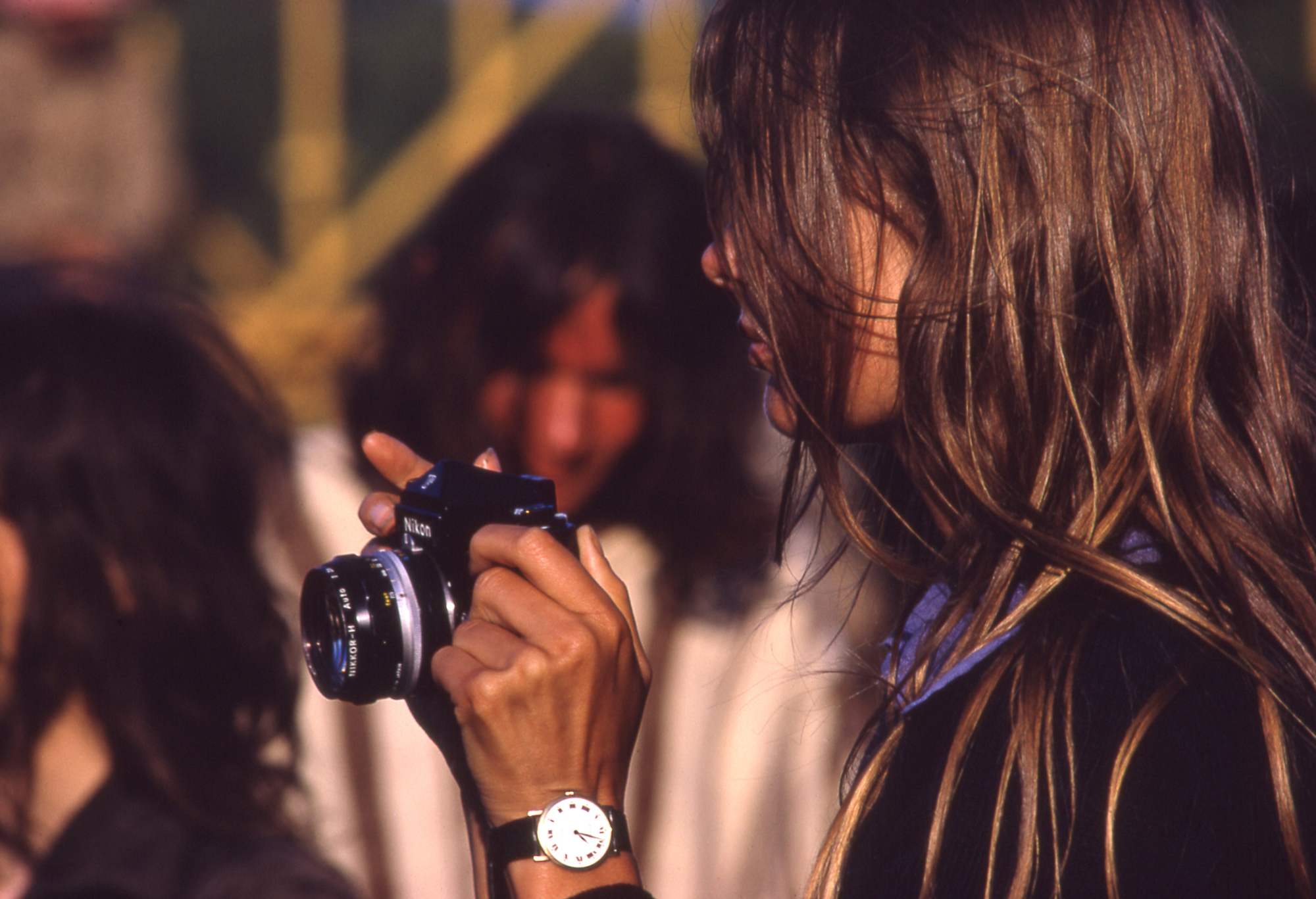 side profile of Jean Shrimpton taking a picture at glastonbury