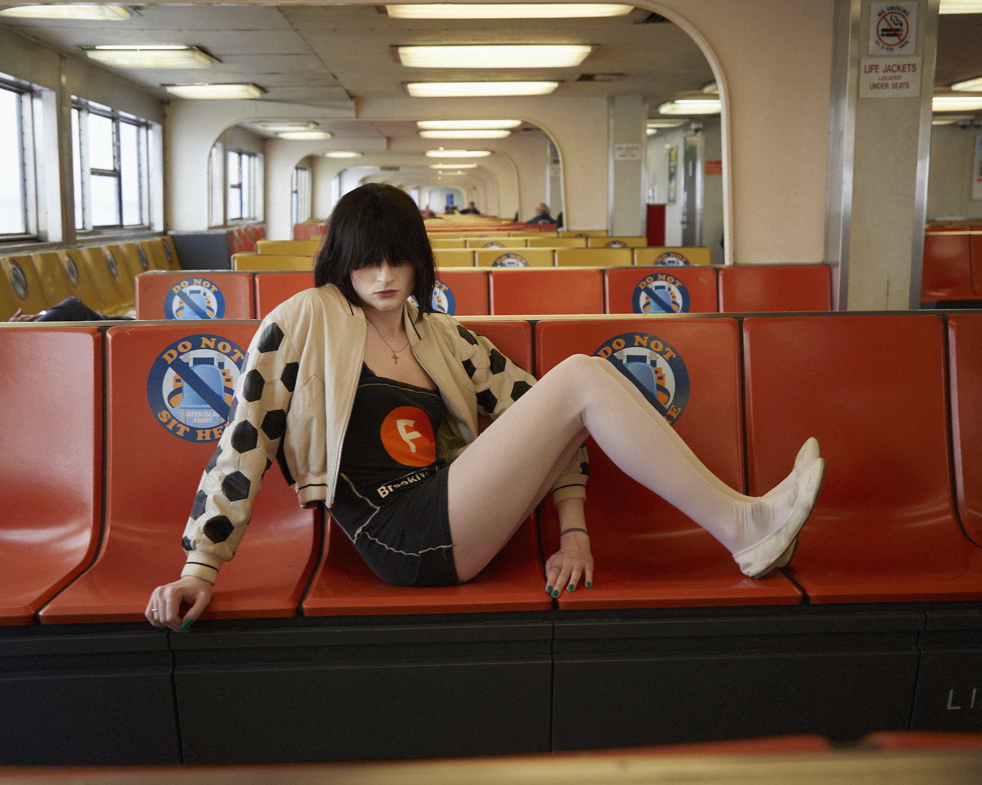 ren g of club eat sitting on the red long island ferry benches