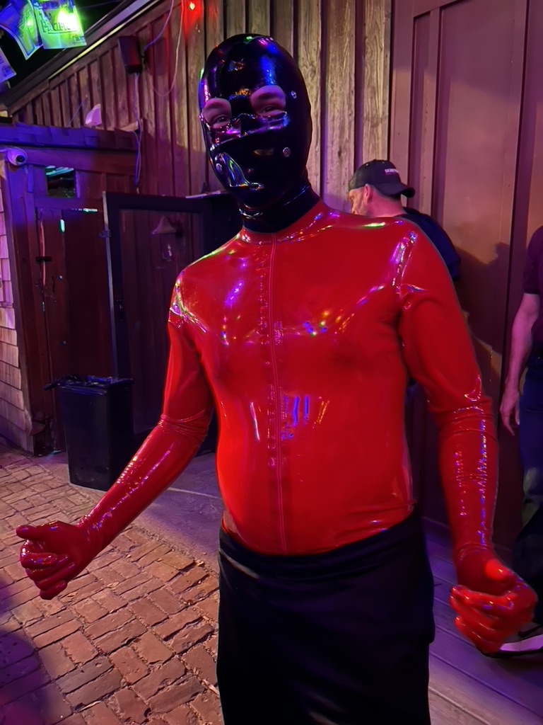 A man in a red latex suit and black full face mask