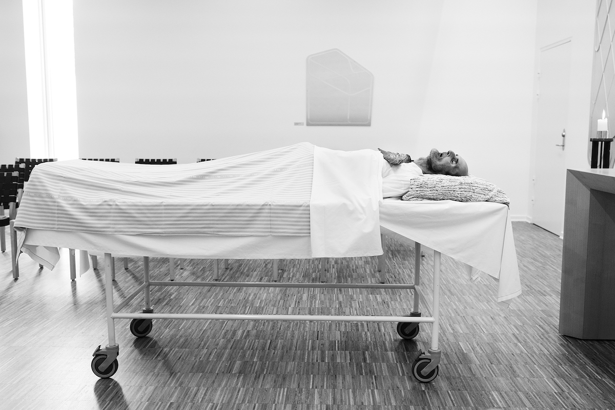 Mikkel Hørlyck, Jørgen, a Mystery – Pedersen lying on a hospital bed in a chapel
