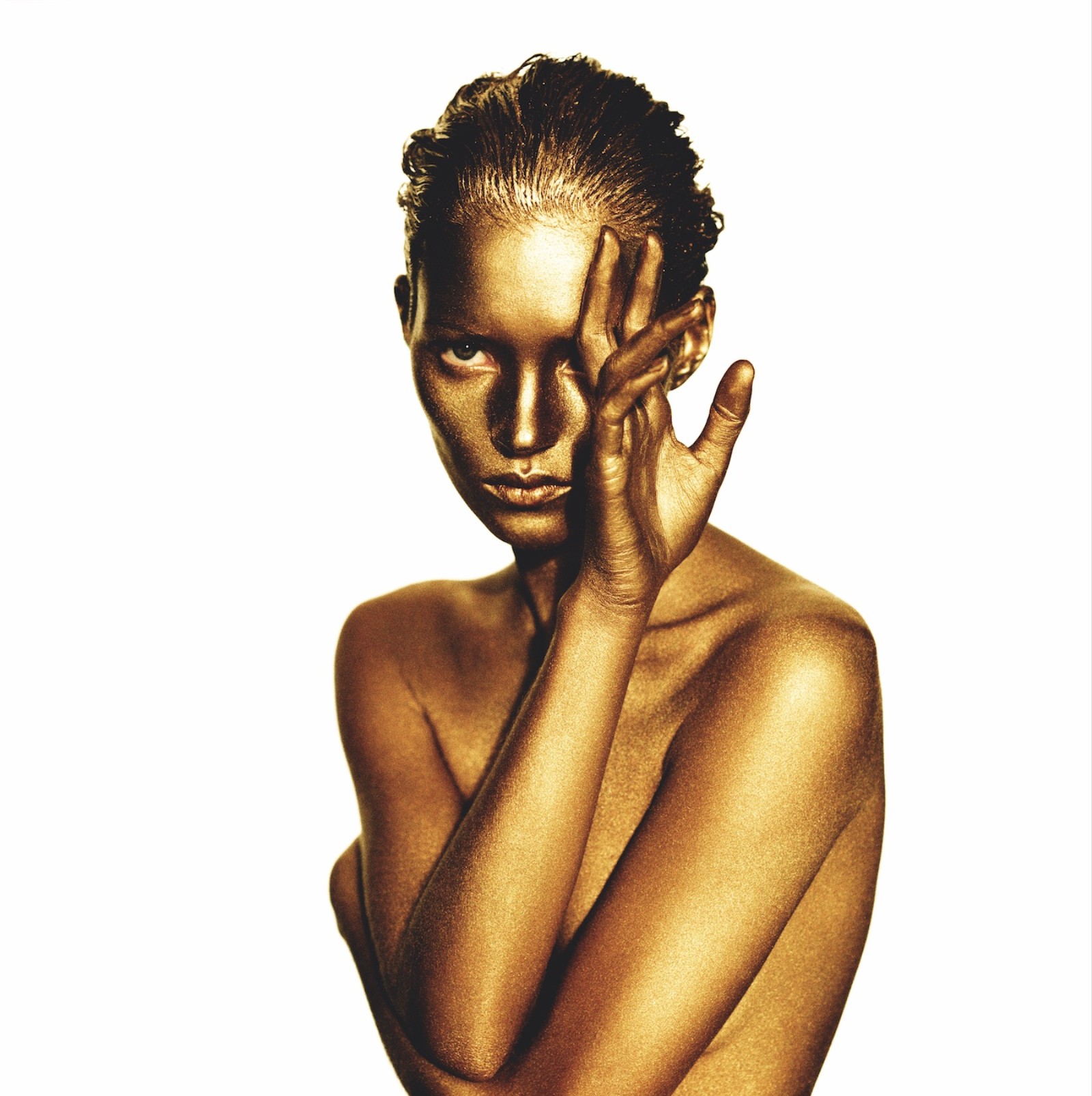 kate moss wearing gold body paint covering one eye