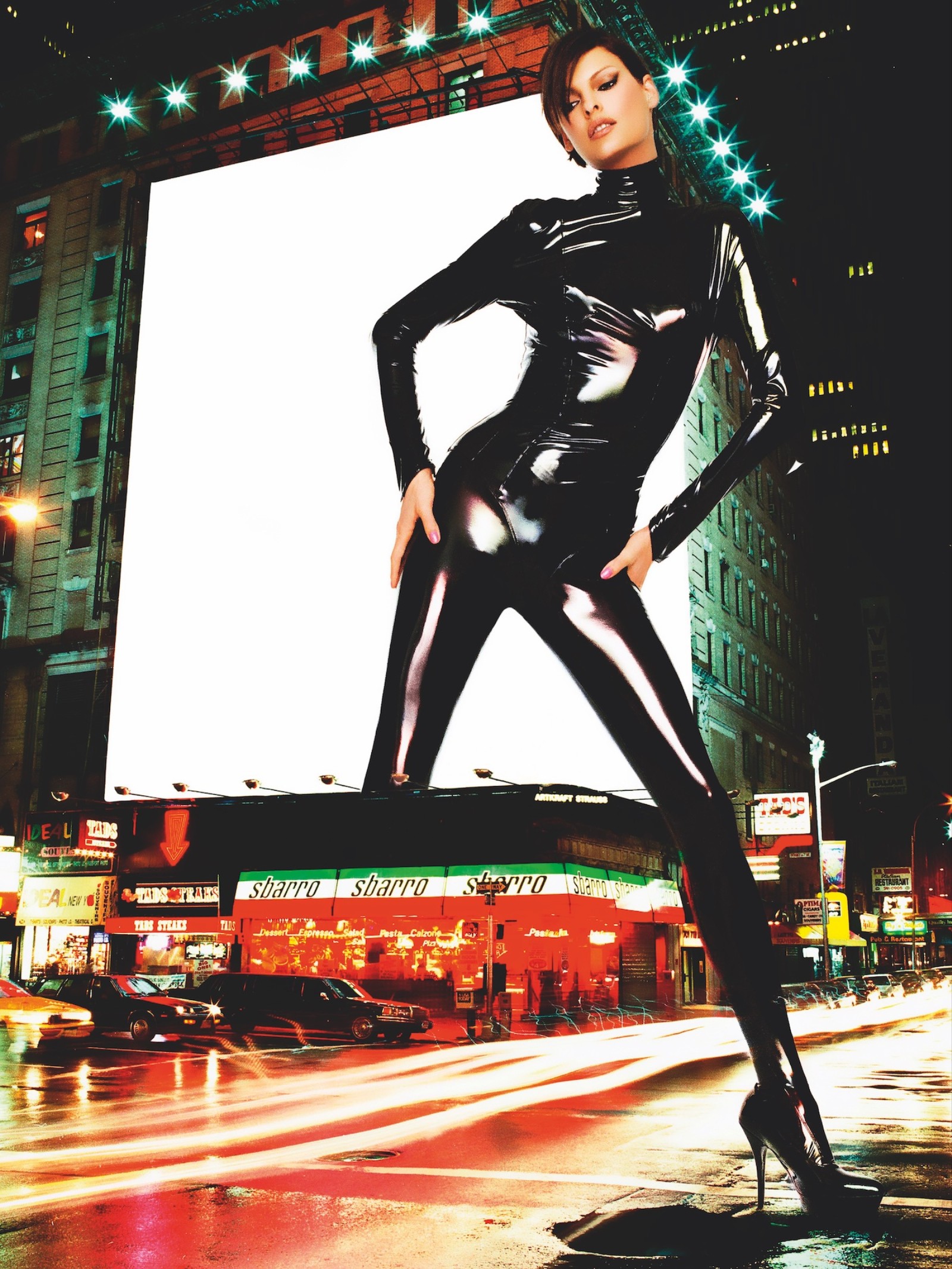 linda evangelista as a giant stnading over a brightly lit cityscape