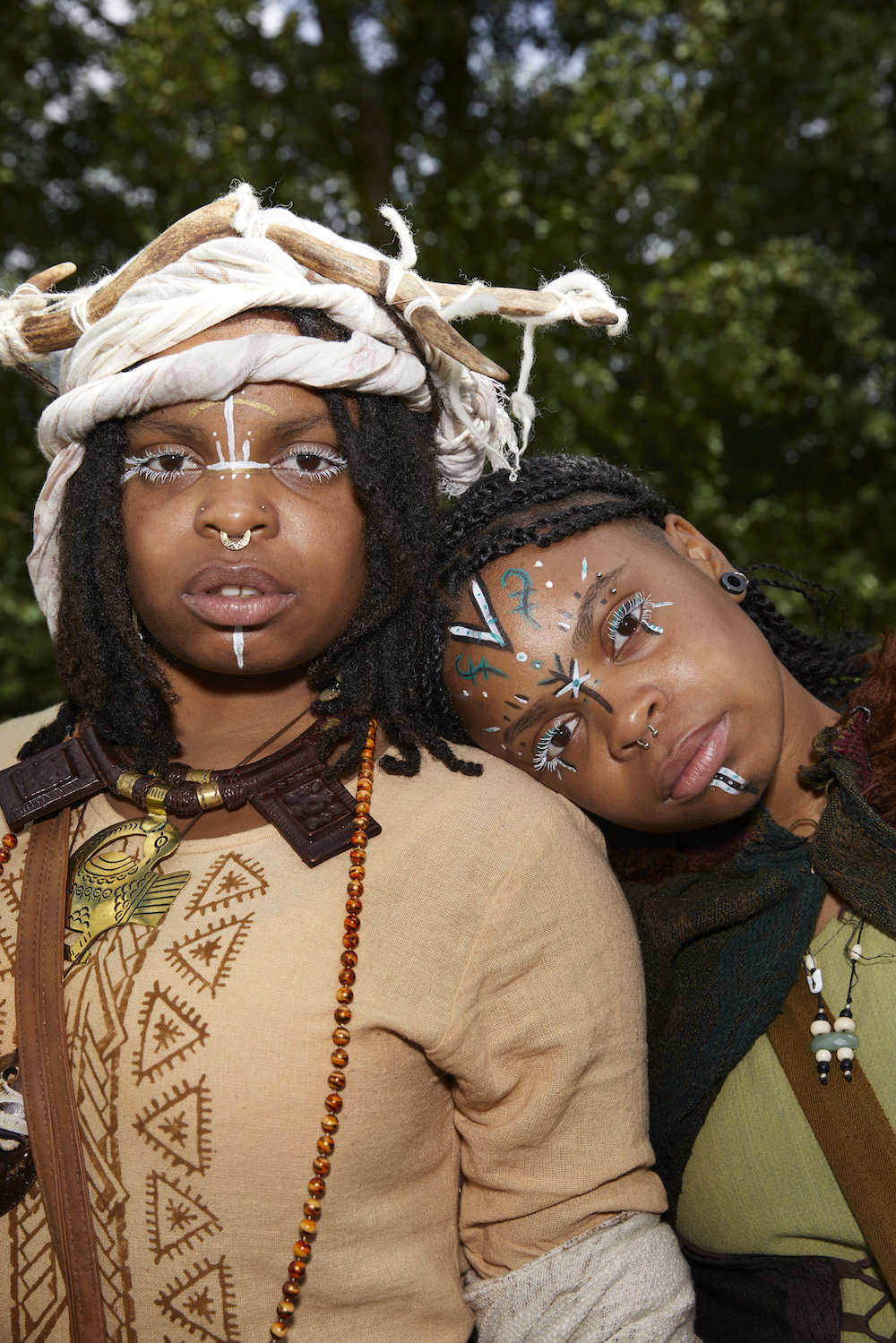 Zwei Frauen mit afrikanischem Schmuck und Mustern und geschminkten Gesichtern