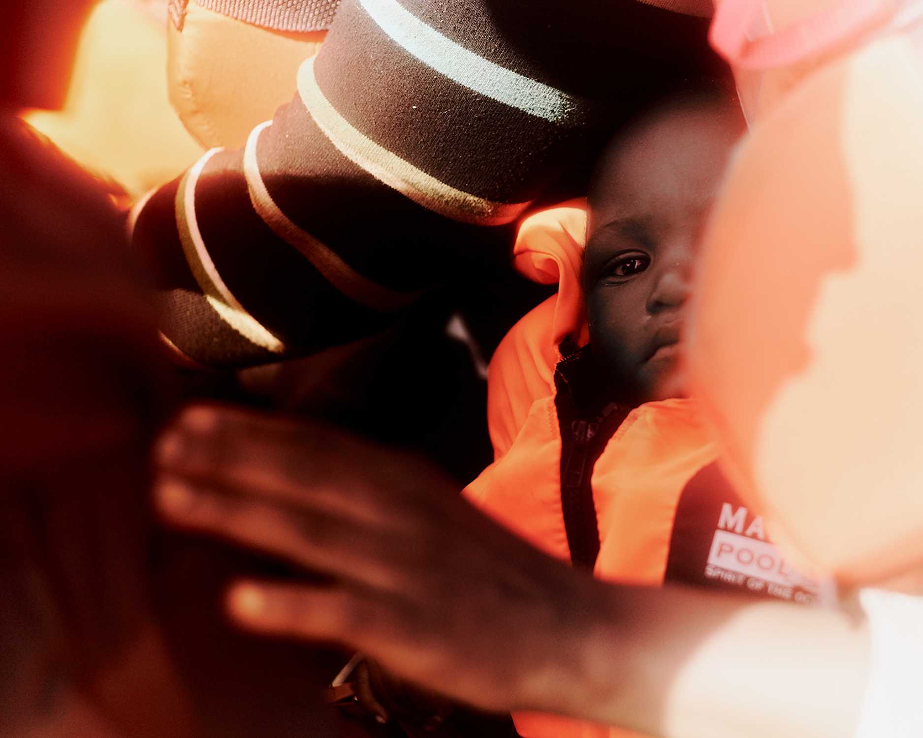 Ein Kleinkind trägt eine orangene Rettungsweste.