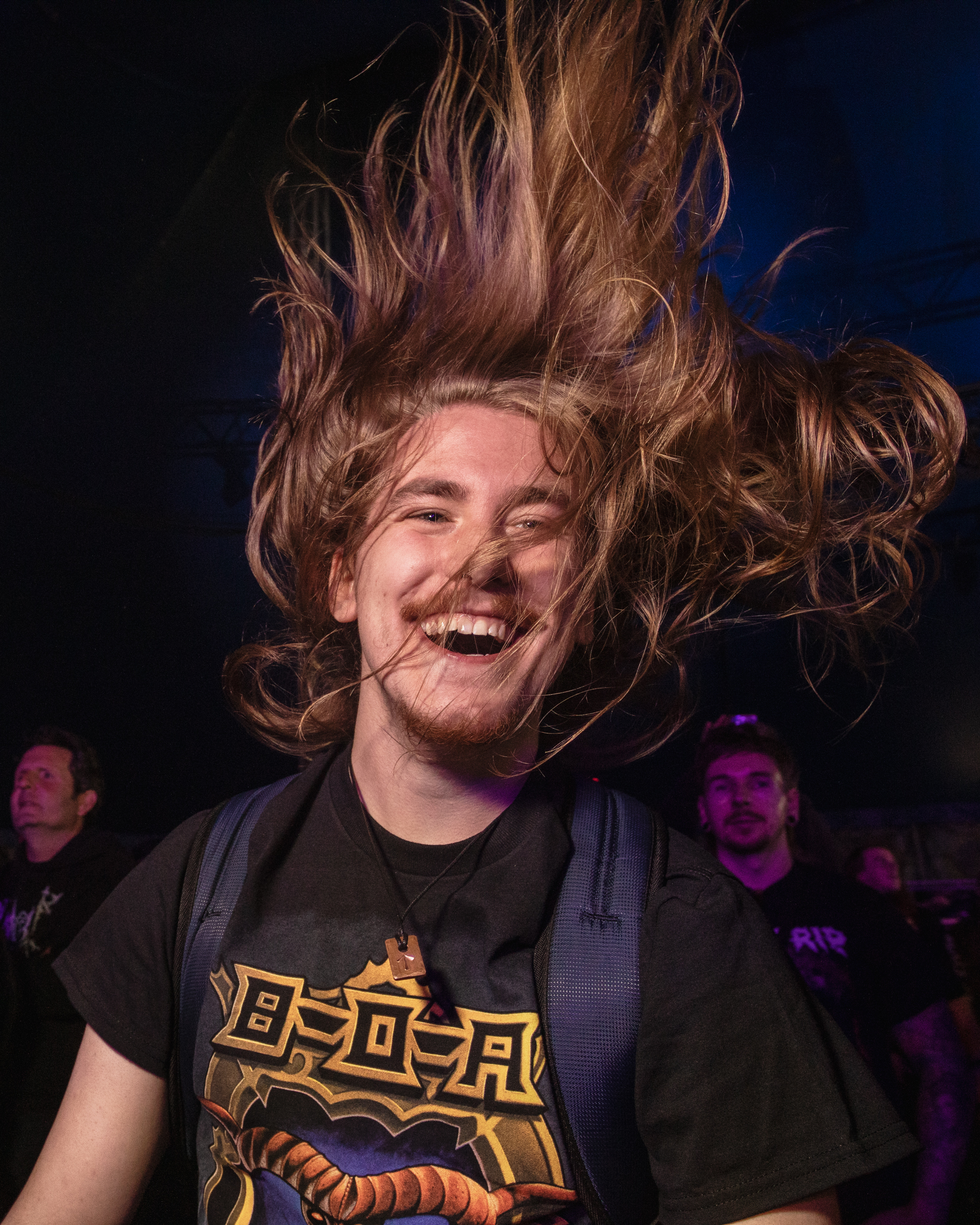 Ein lächelnder Mann mit langen Haaren beim Headbangen