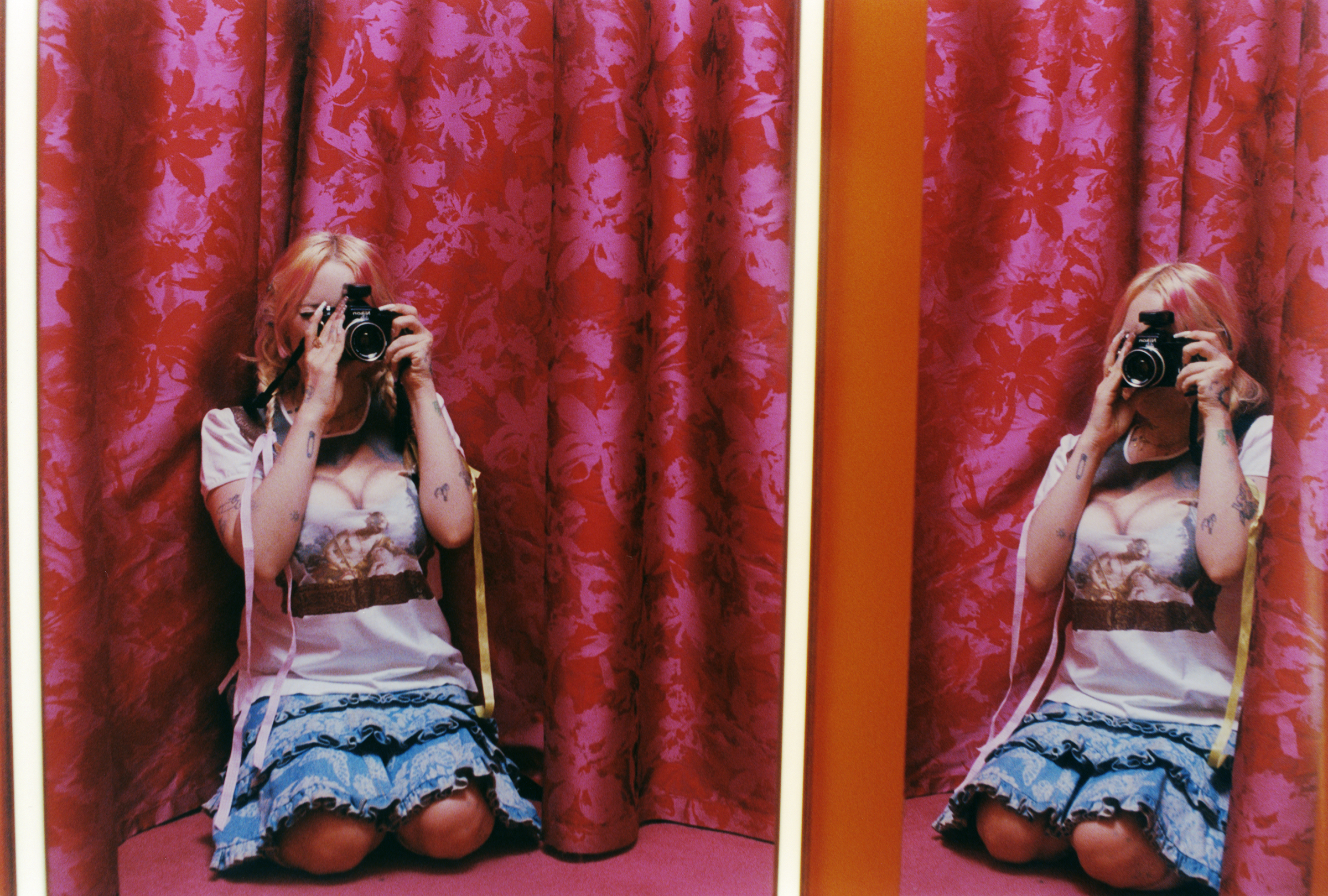 harmony tividad taking a self portrait in a dressing room with pink curtains. Photography Ashley Markle