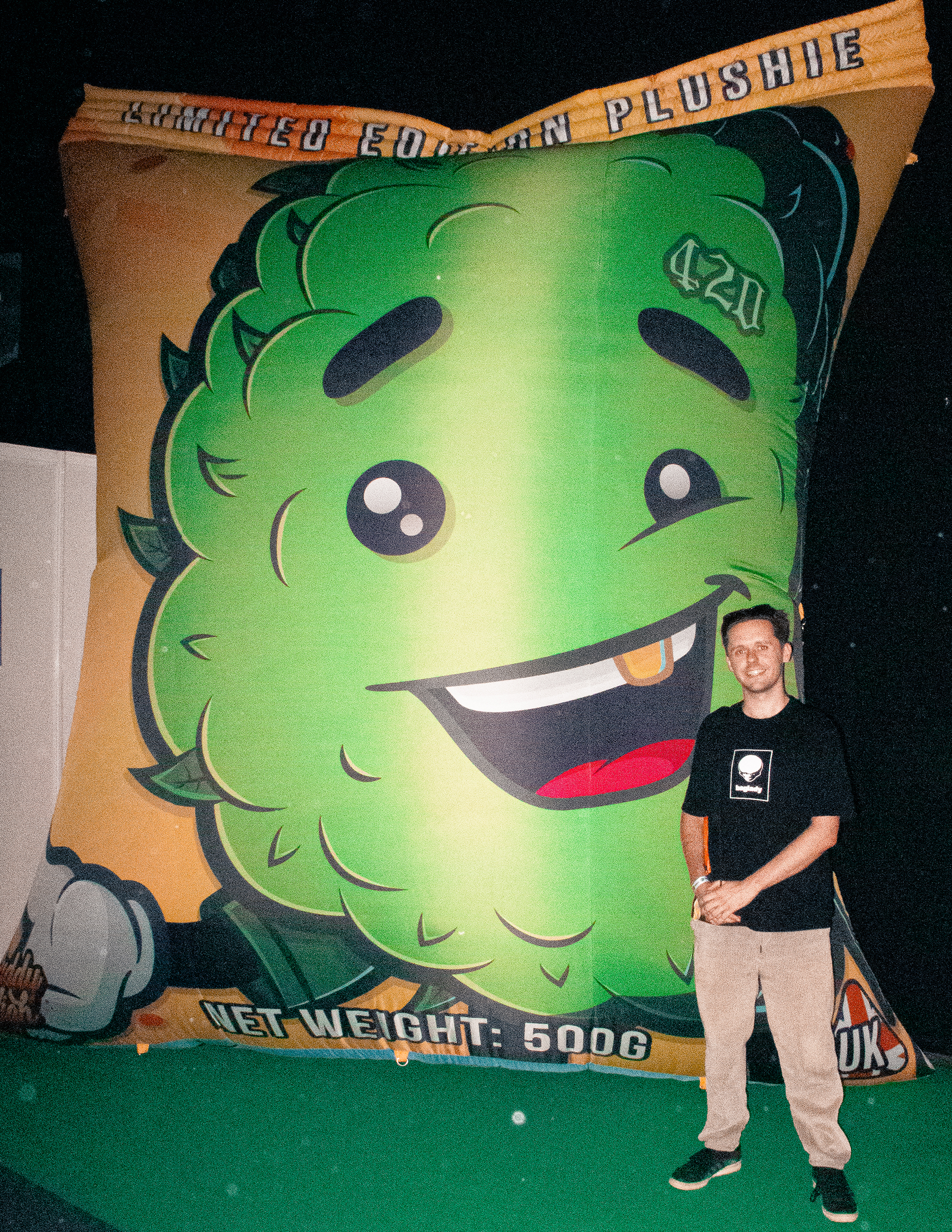 Writer in front of a big weed cushion at Product Earth UK cannabis event.