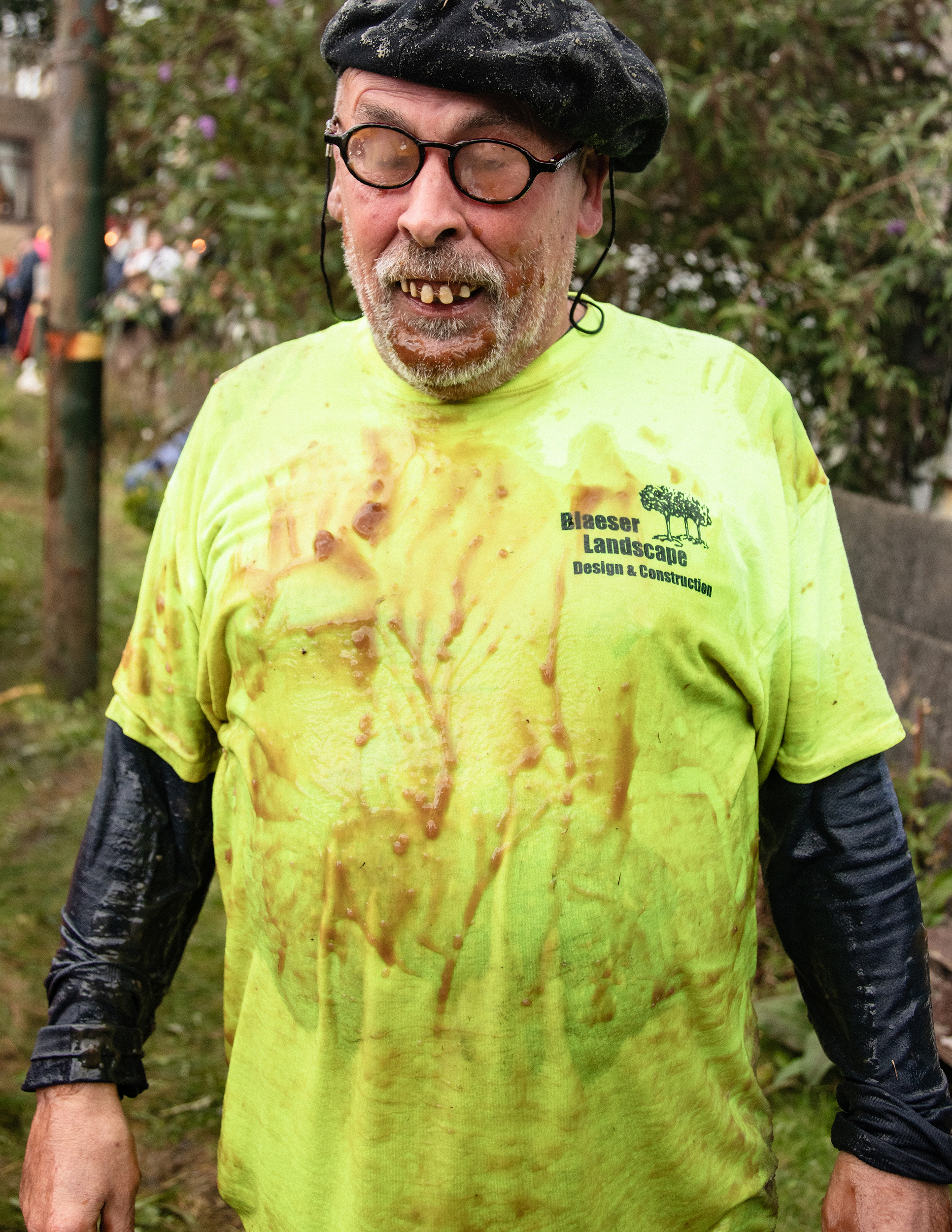 world gravy championships - a portrait of a man in a beret with joke false teeth covered in mud.