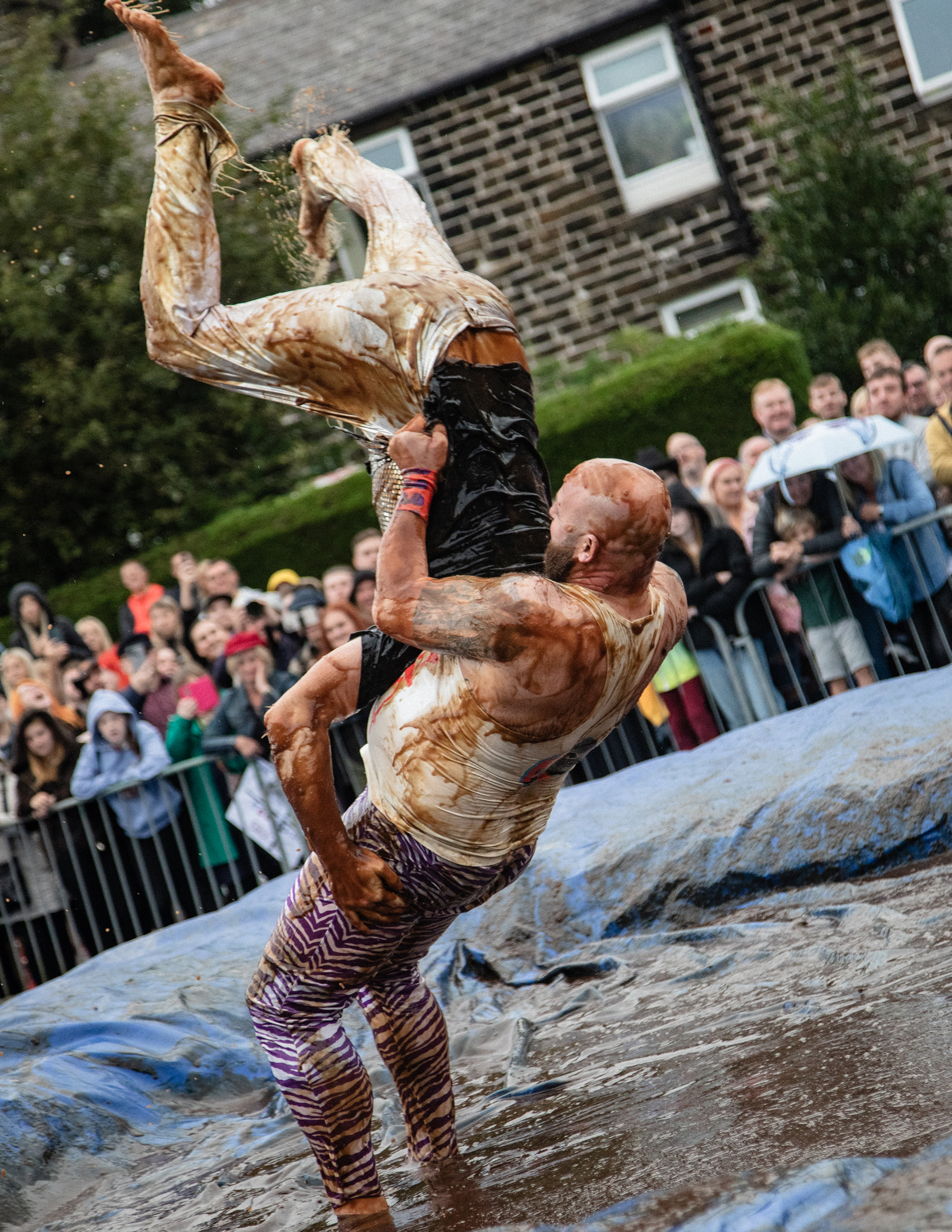 world gravy championships - a photo of two people wrestling in a gravy filled wrestling ring.