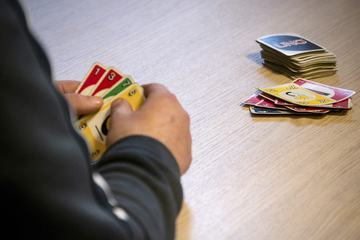 Transit, Brussels – close-up of male hands playing UNO.