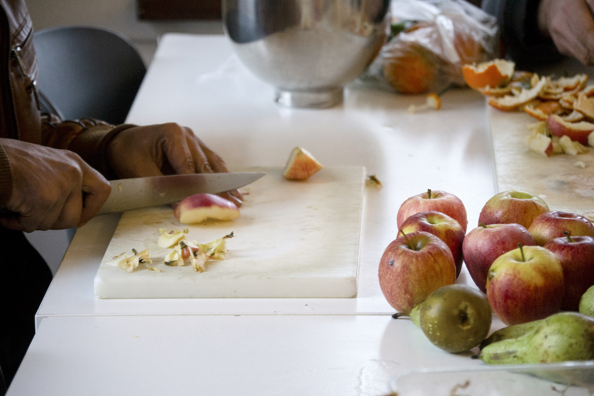 Transit, Brussels – closeup of hands cutting apples into slices.