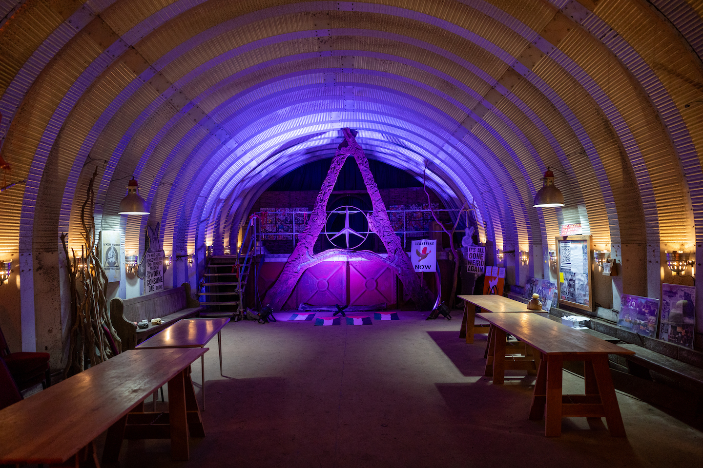 A photo of a DIY chapel lit by purple lighting and with a gigantic A at the altar.