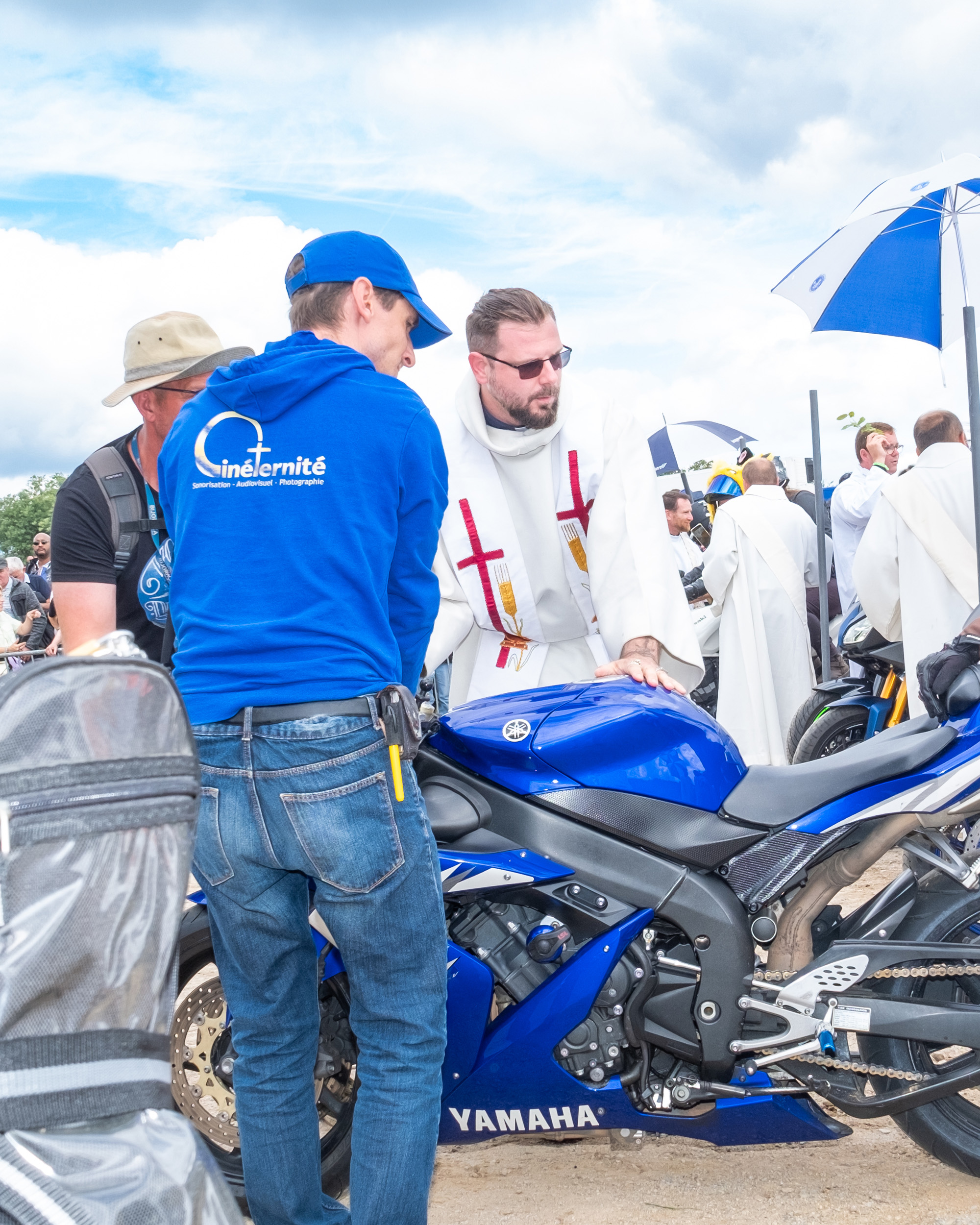 priest bless motorcycle rider at Le Pardon des Motards pilgrimage in porcaro brittany france