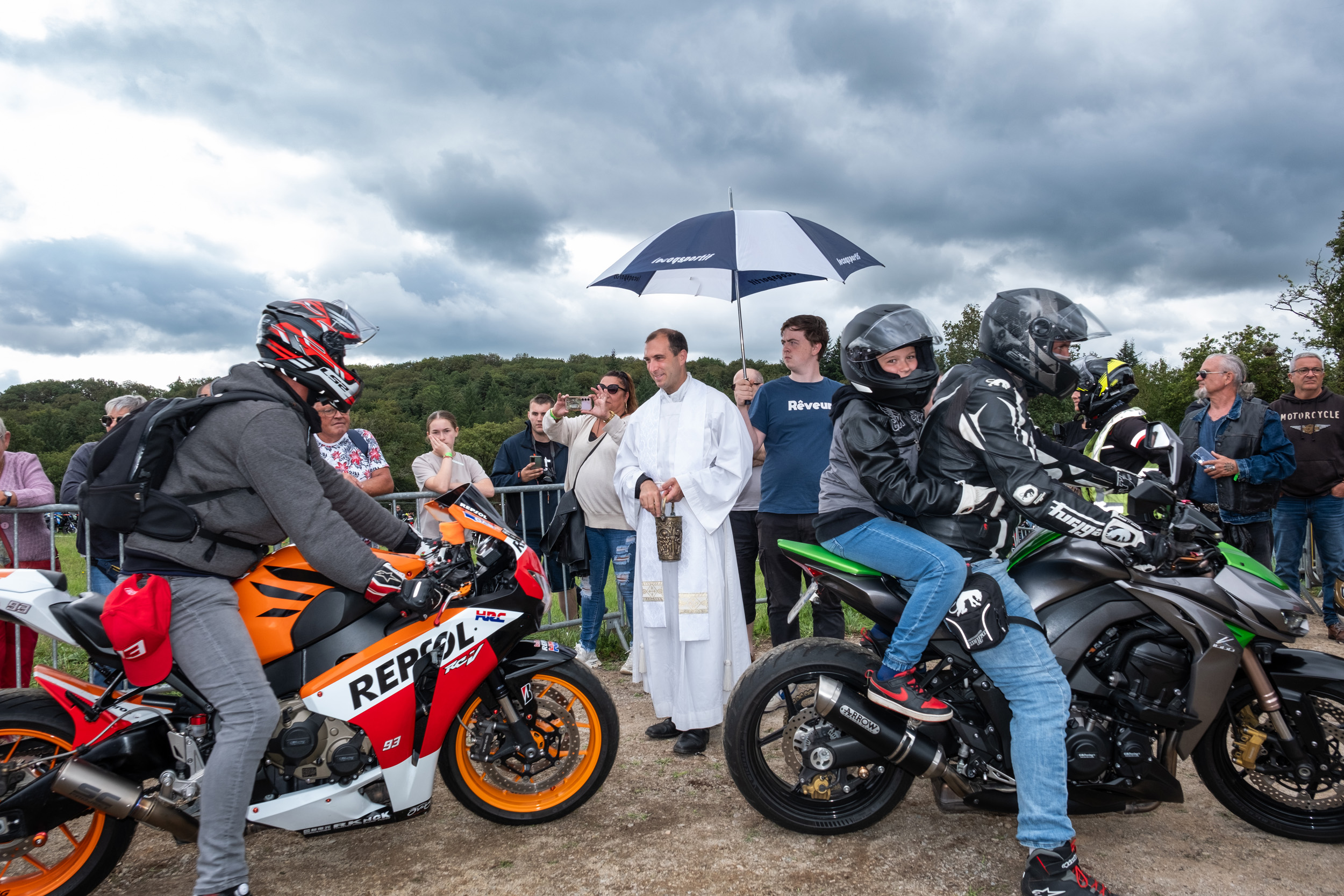 priest bless motorcycle rider at Le Pardon des Motards pilgrimage in porcaro brittany france