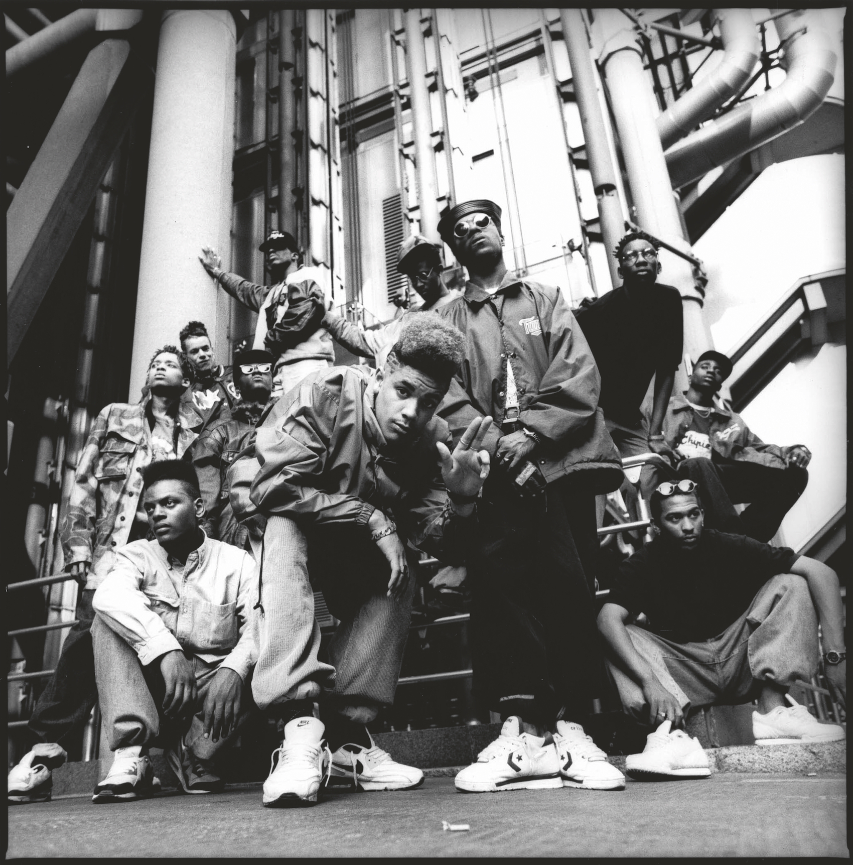 A large group of musicians pose outside a bank building in central London.