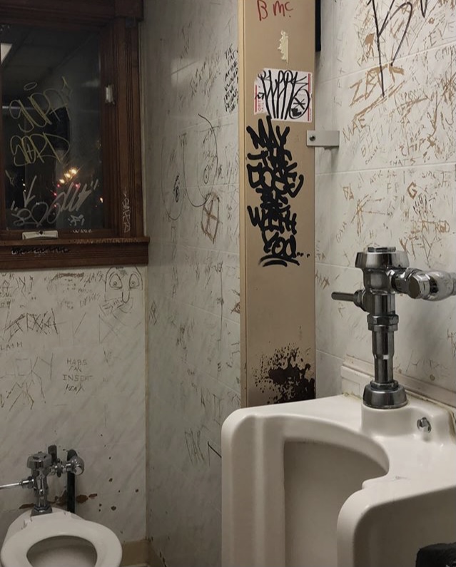 A photo of the graffiti marked toilets in a bar.