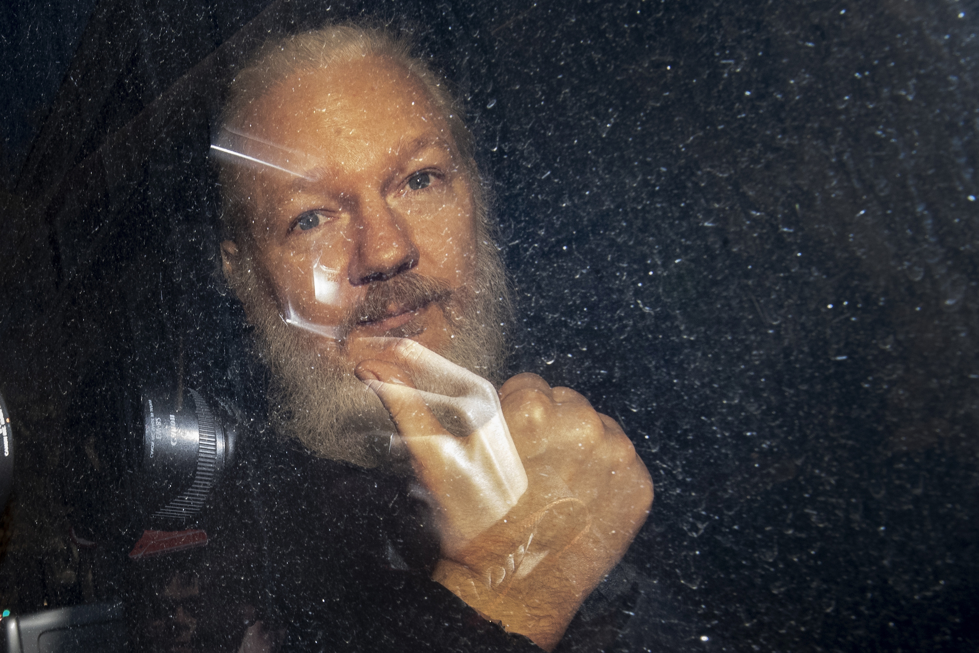 Julian Assange Beams In From Prison For His First Extradition Hearing ...